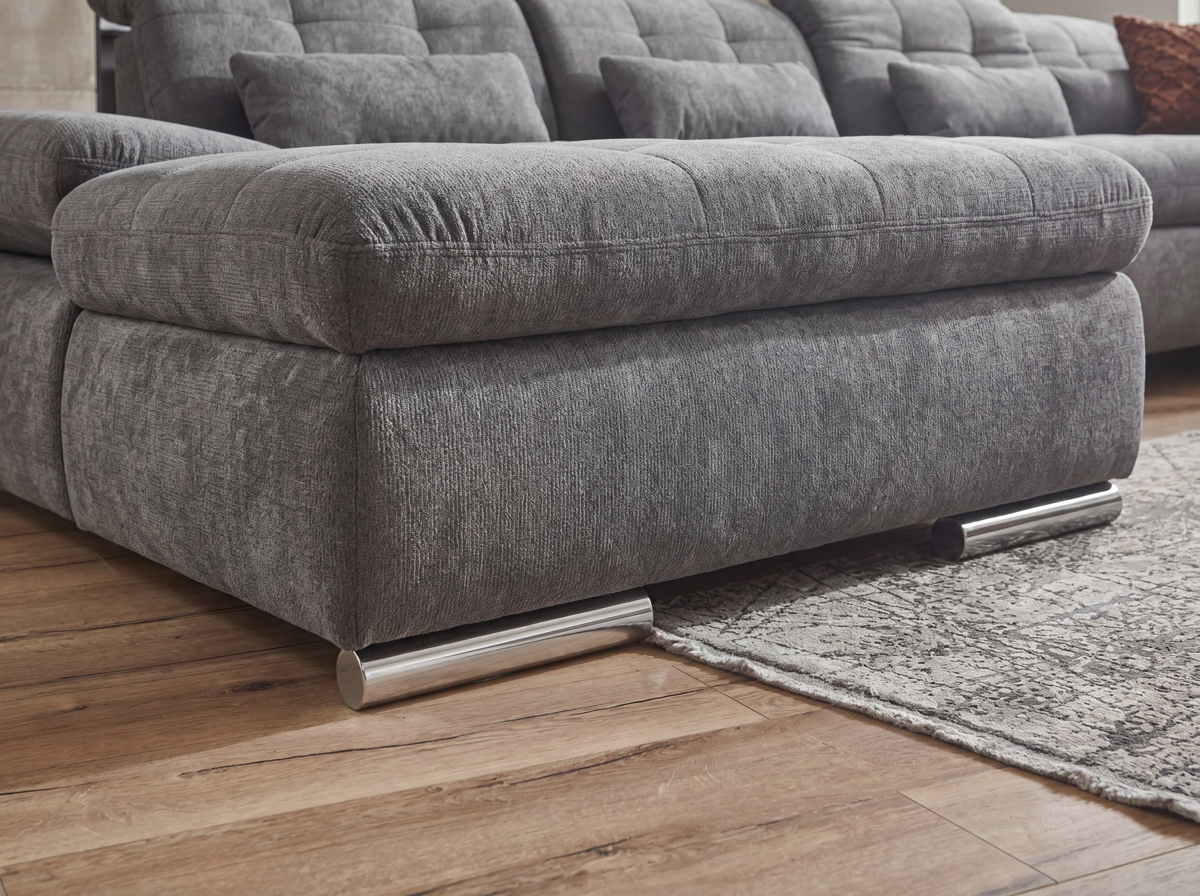Ecksofa mit grauem Stoffbezug, breiter Sitzfläche, gesteppten Polstern und runden Metallfüßen