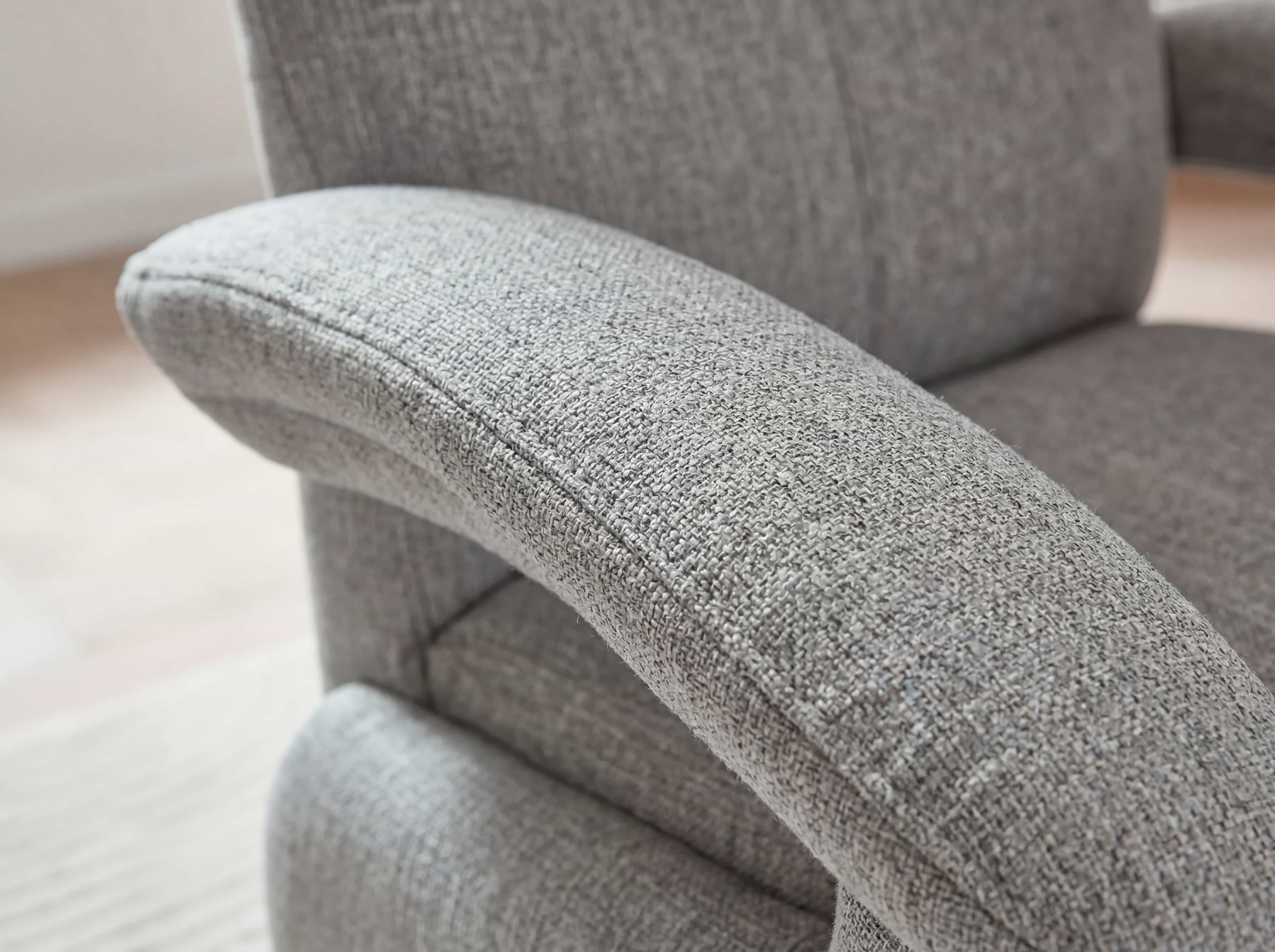 Sofa Kabs Polsterwelt mit grauem Stoffbezug, sichtbarer Armlehne und strukturierter Oberfläche