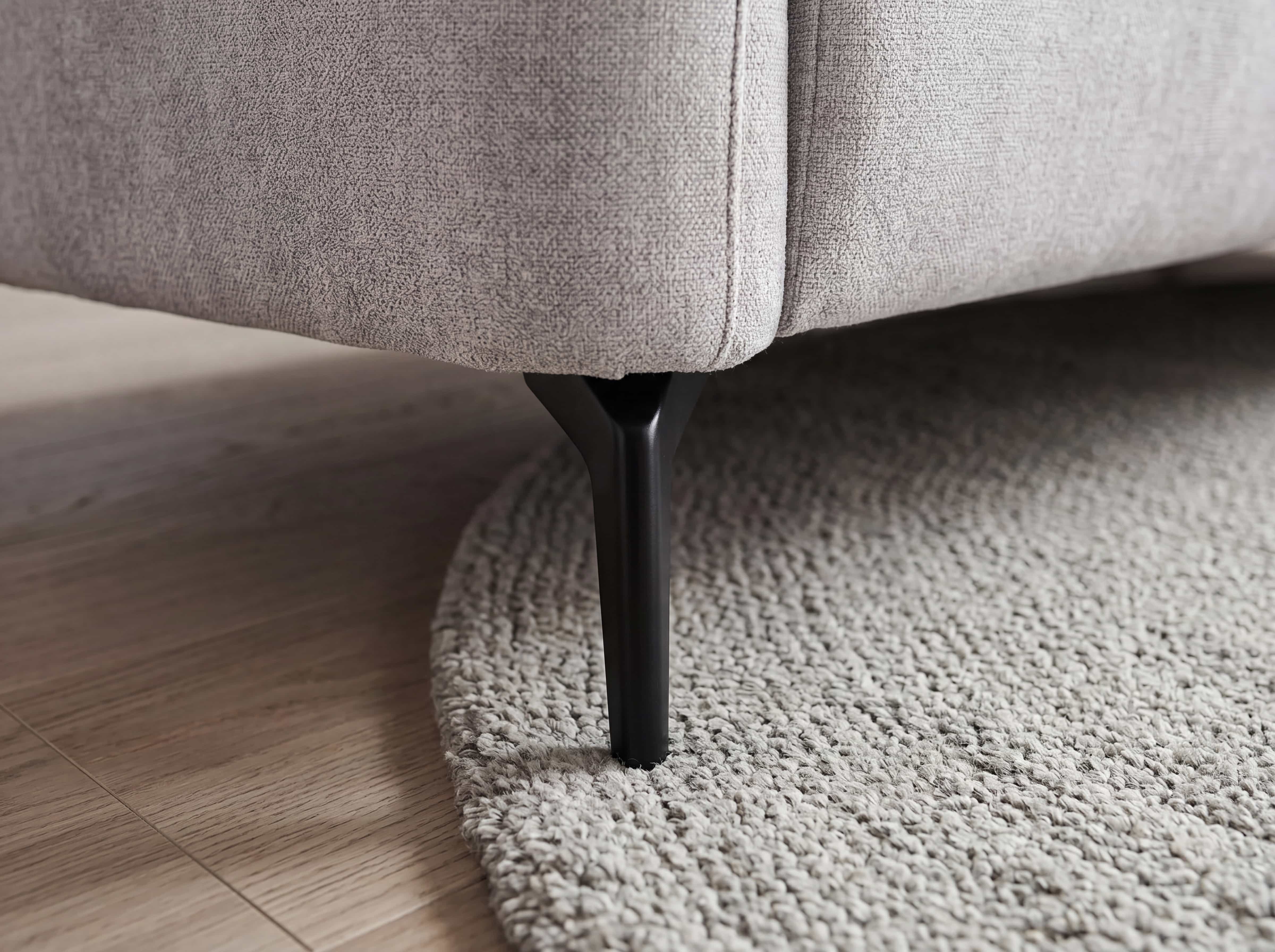 Ecksofa Kabs Polsterwelt mit grauem Stoffbezug und mattschwarzem Metallfuß in Nahaufnahme