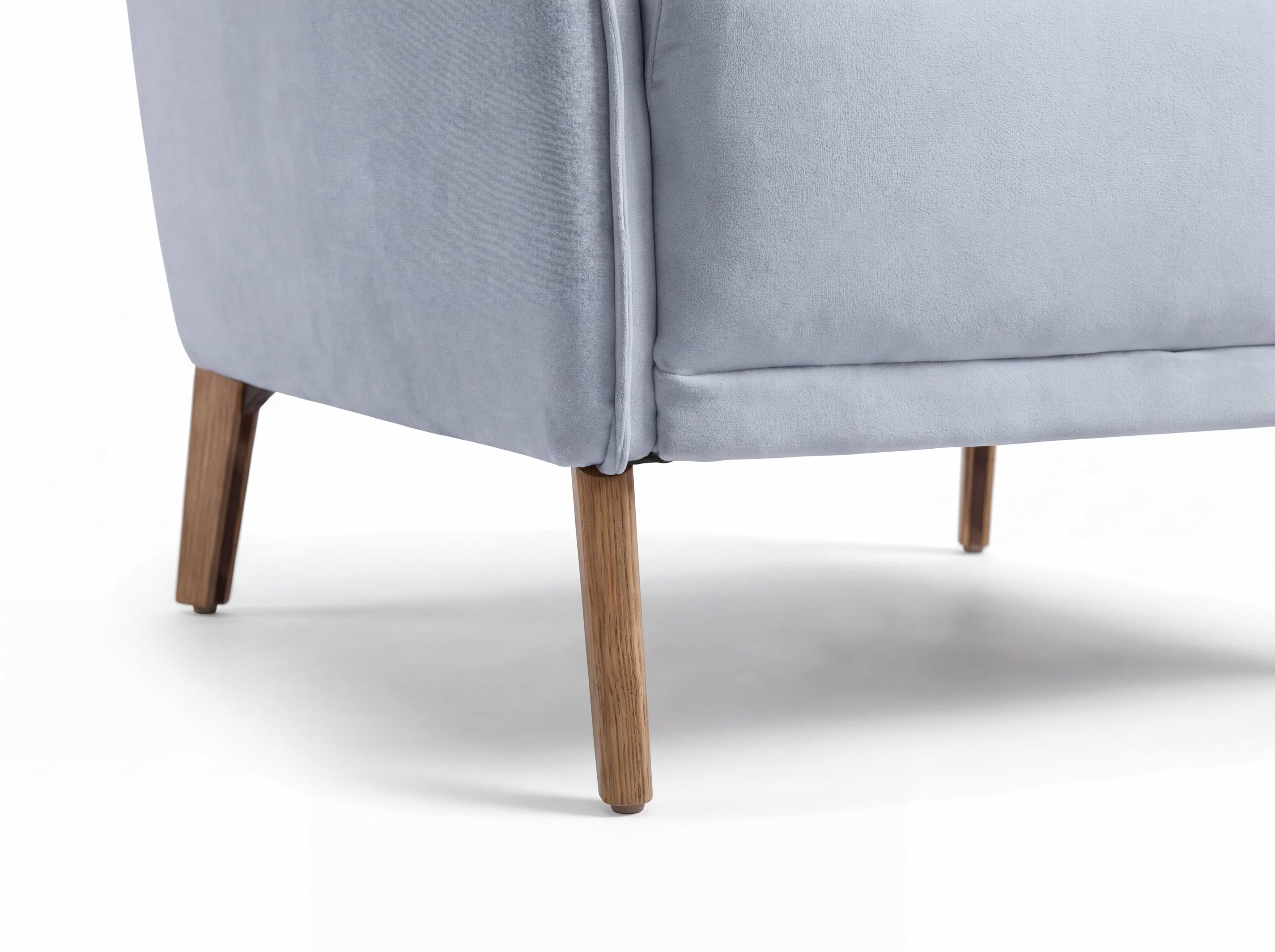 Ecksofa mit hellblauem Stoffbezug und vier konisch zulaufenden Beinen aus Holz im Detailansicht