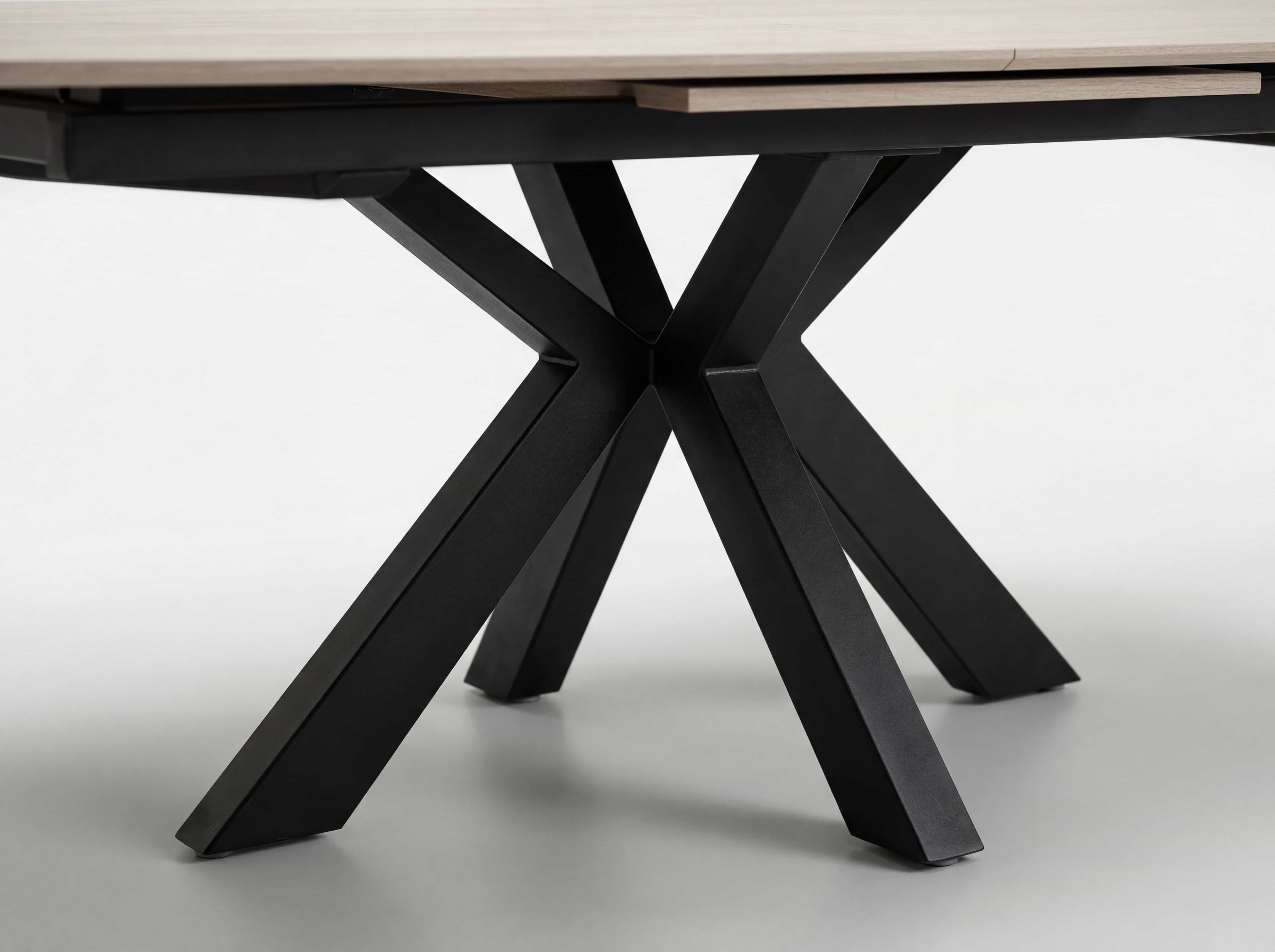 Esstisch mit heller Holzplatte und schwarzem Metallgestell in Kreuzform, modern gestaltet