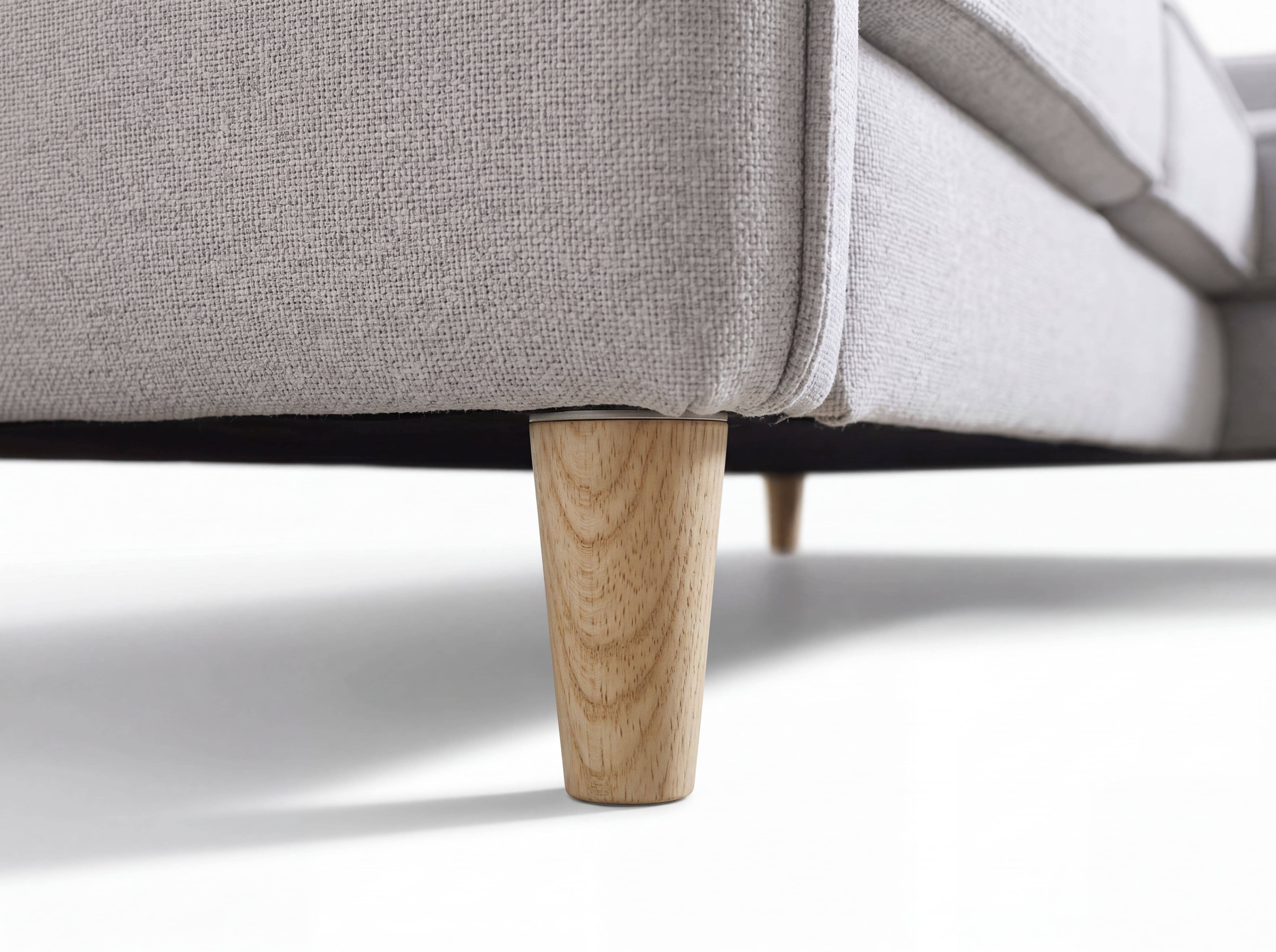 Sofa mit hellgrauem Stoffbezug und konischen Holzfüßen, Detailansicht der unteren Ecke