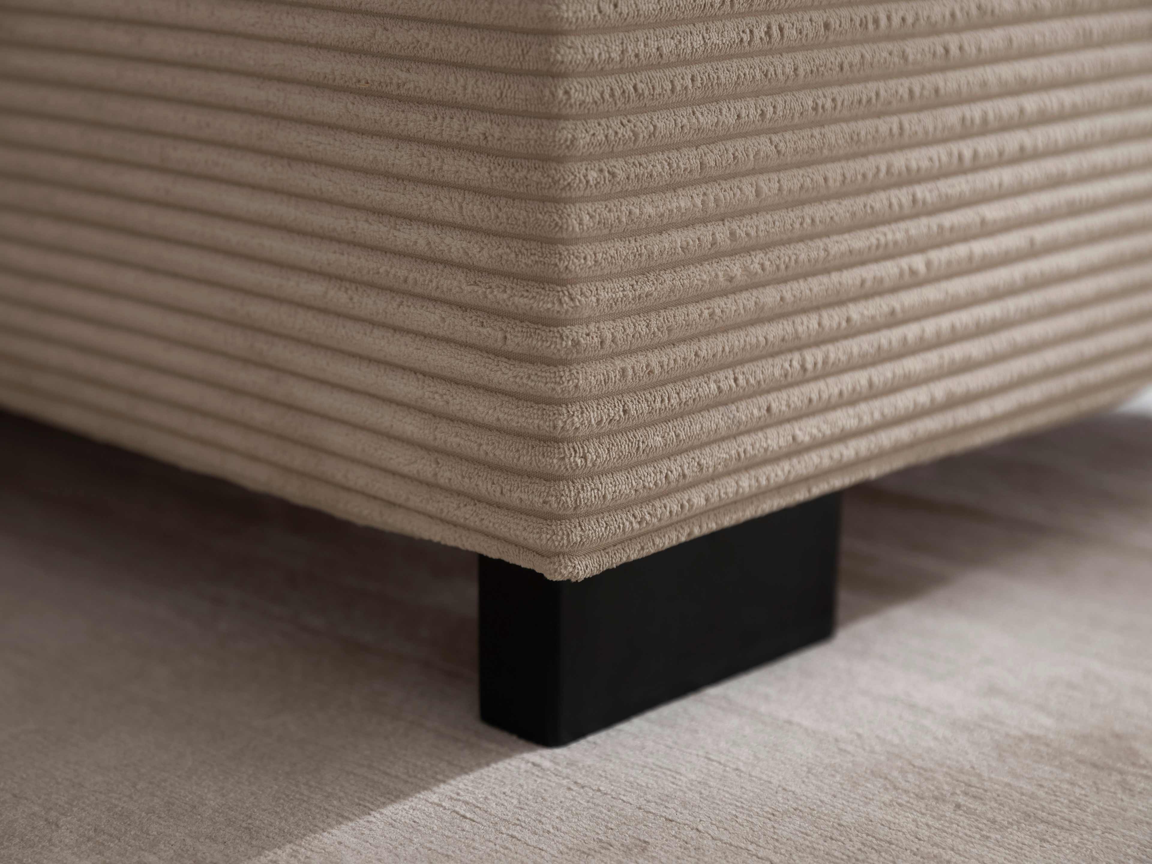 Boxspringbett mit beigefarbenem, geriffelten Stoffbezug und schwarzem, eckigem Fußgestell