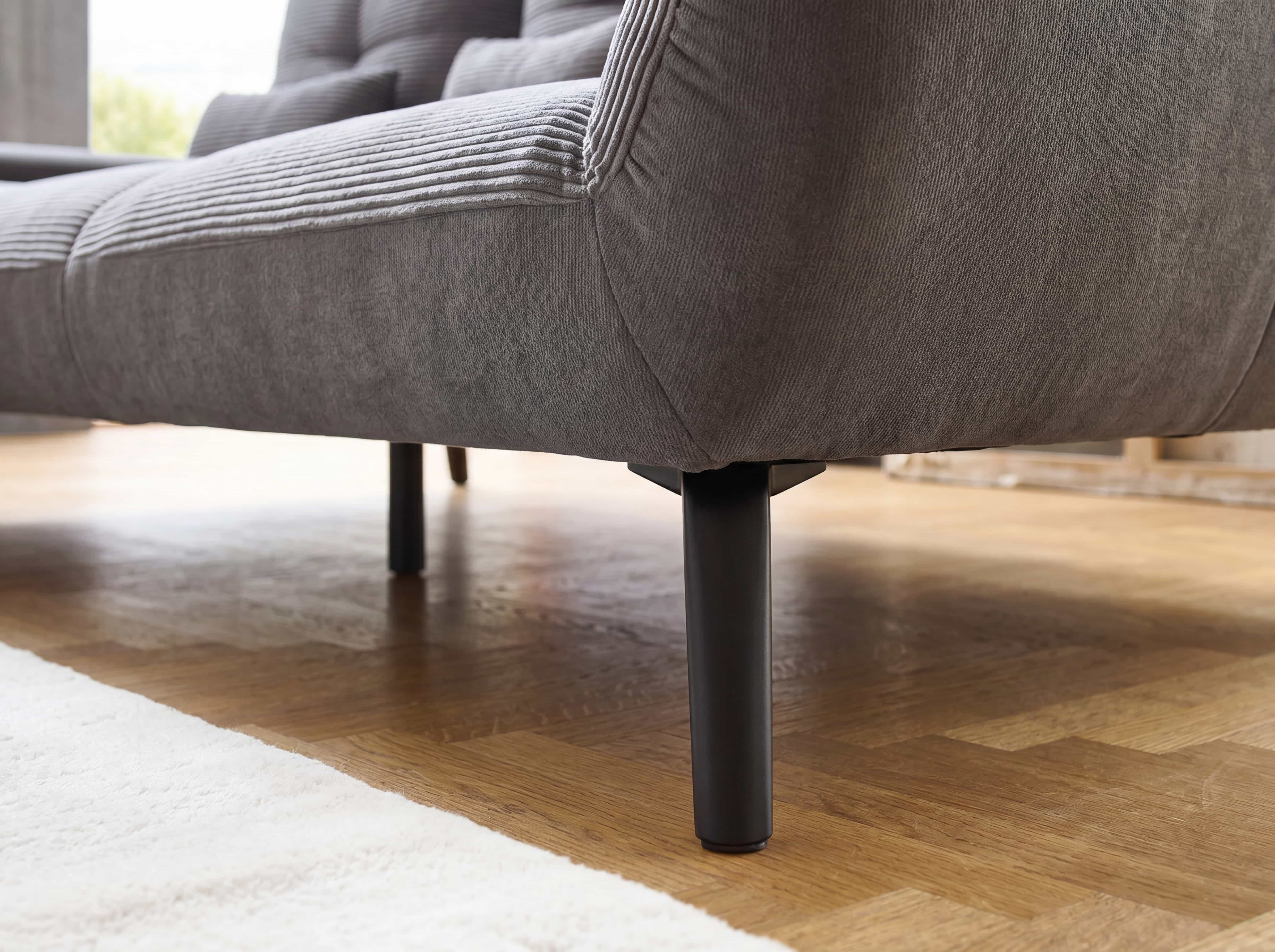 Ecksofa Paola – Detailansicht des grauen Cordbezugs mit schwarzen runden Metallfüßen