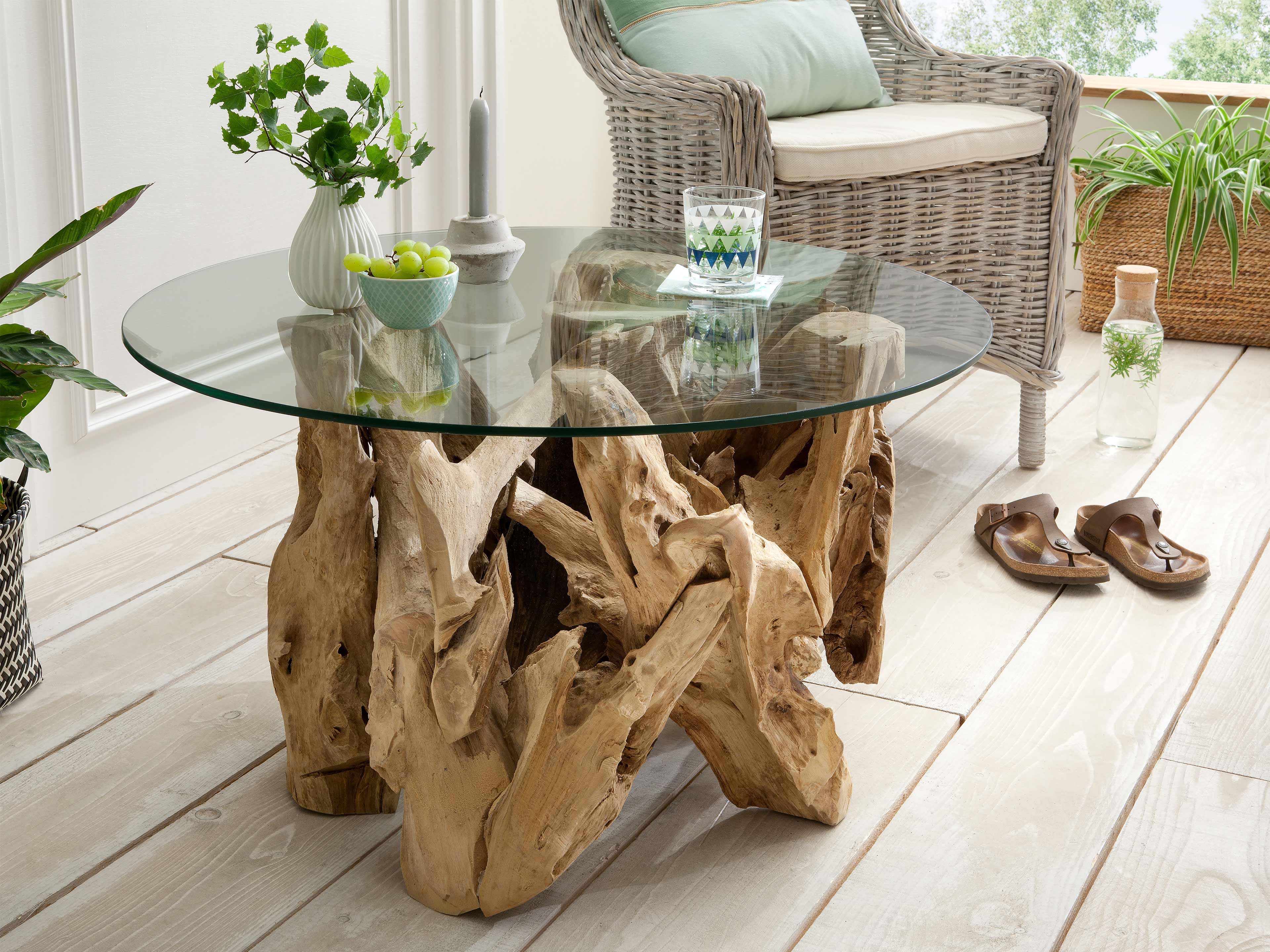 Couchtisch mit runder Glasplatte und naturbelassenem Gestell aus hellem Massivholz in Aststruktur