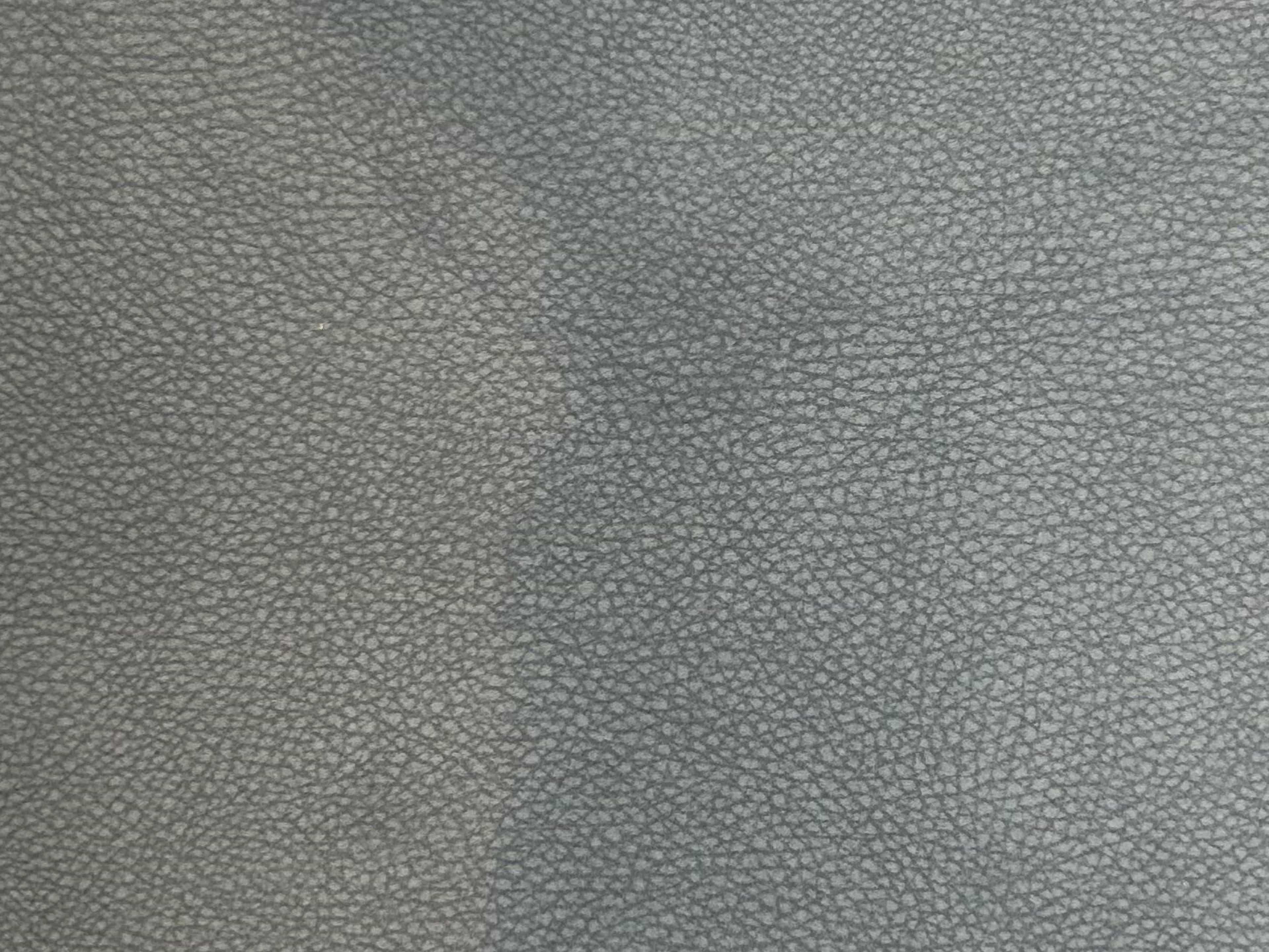 Graues Leder mit feiner Narbenstruktur und sichtbarer Maserung, Detailaufnahme der Oberfläche