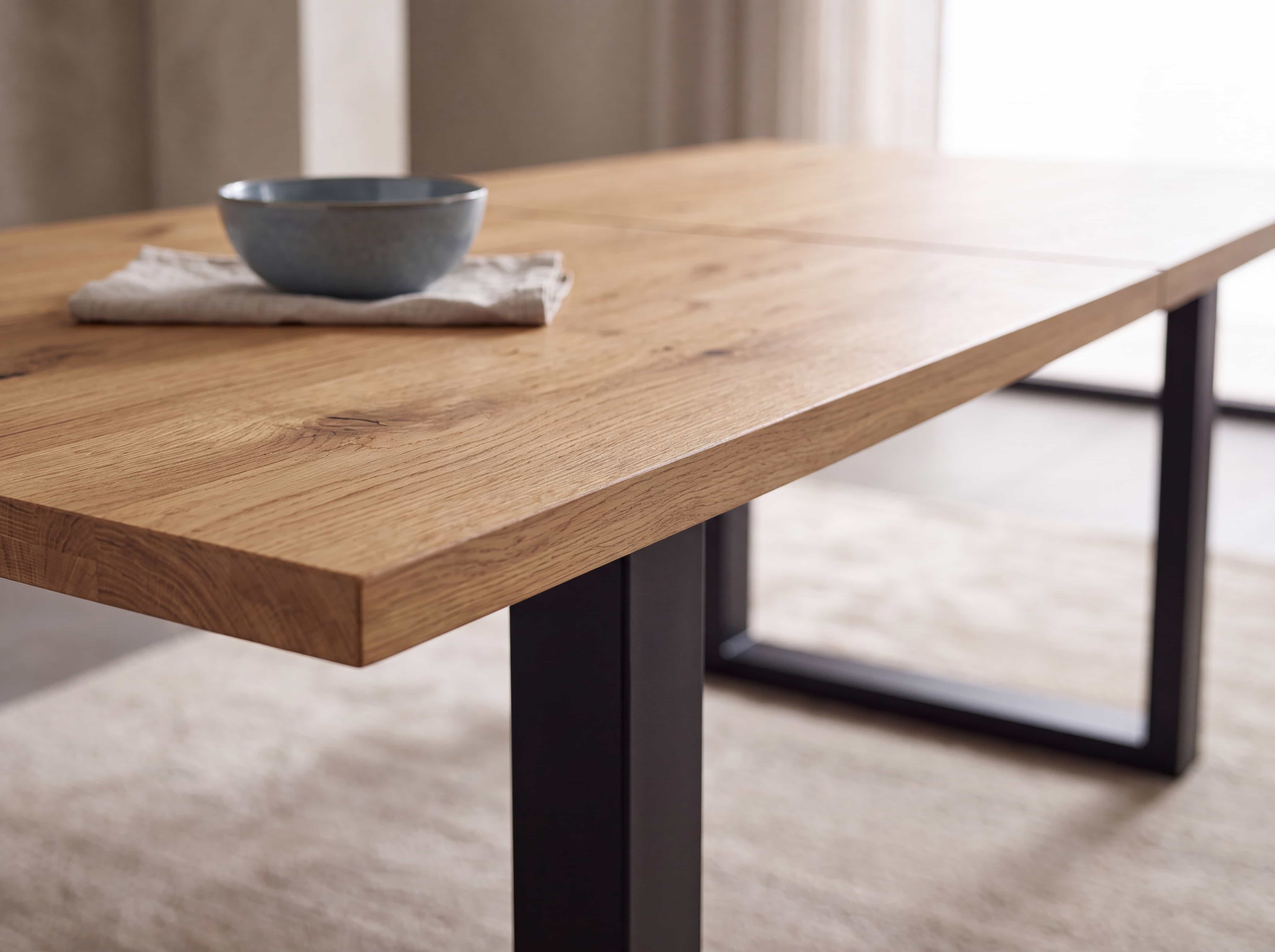 Esstisch mit rechteckiger Tischplatte aus hellem Holz und schwarzem Metallgestell in U-Form