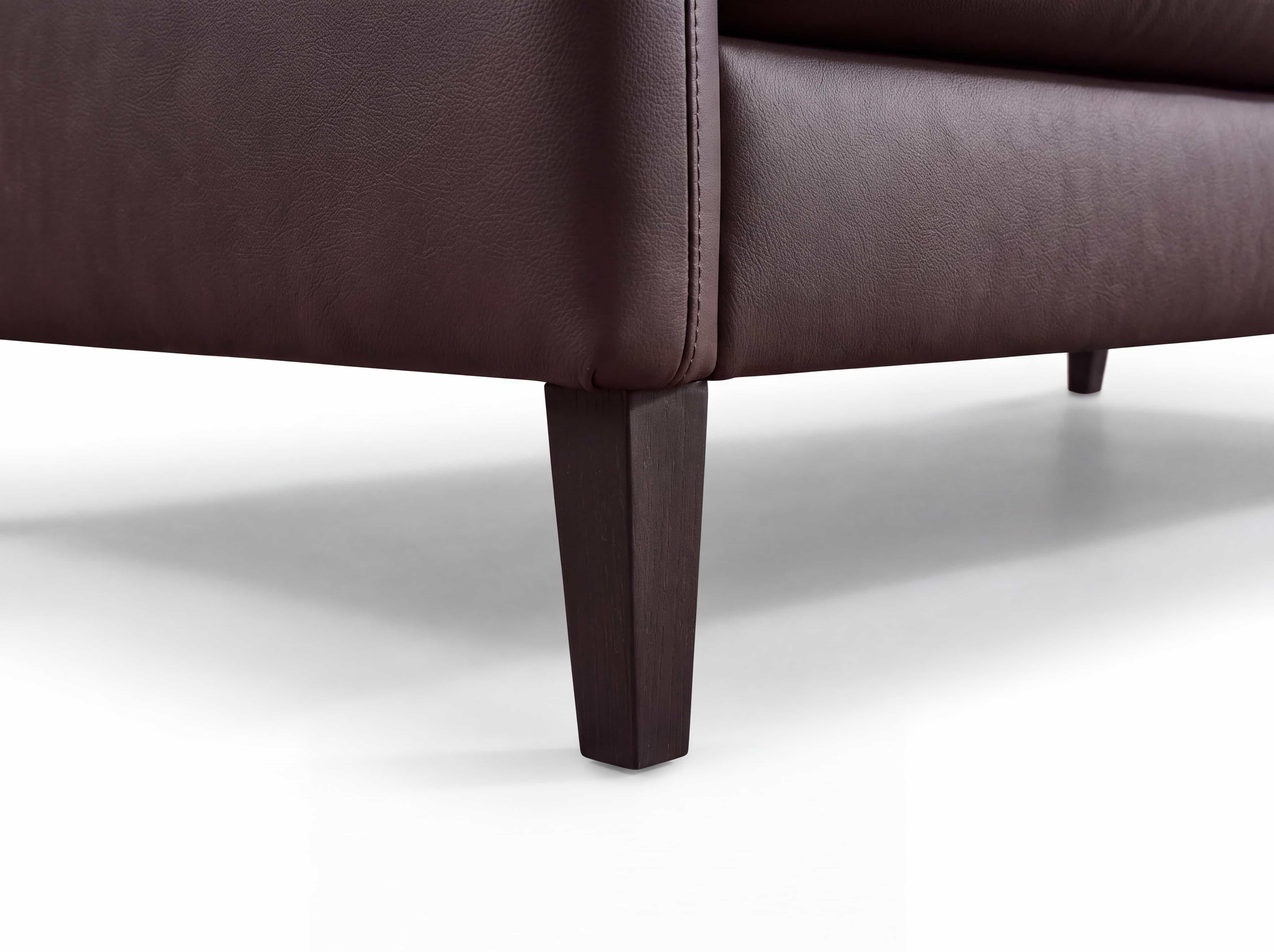 Einzelsofa Pinot – Detailansicht des braunen Bezugs mit dunklem, eckigem Holzfuß