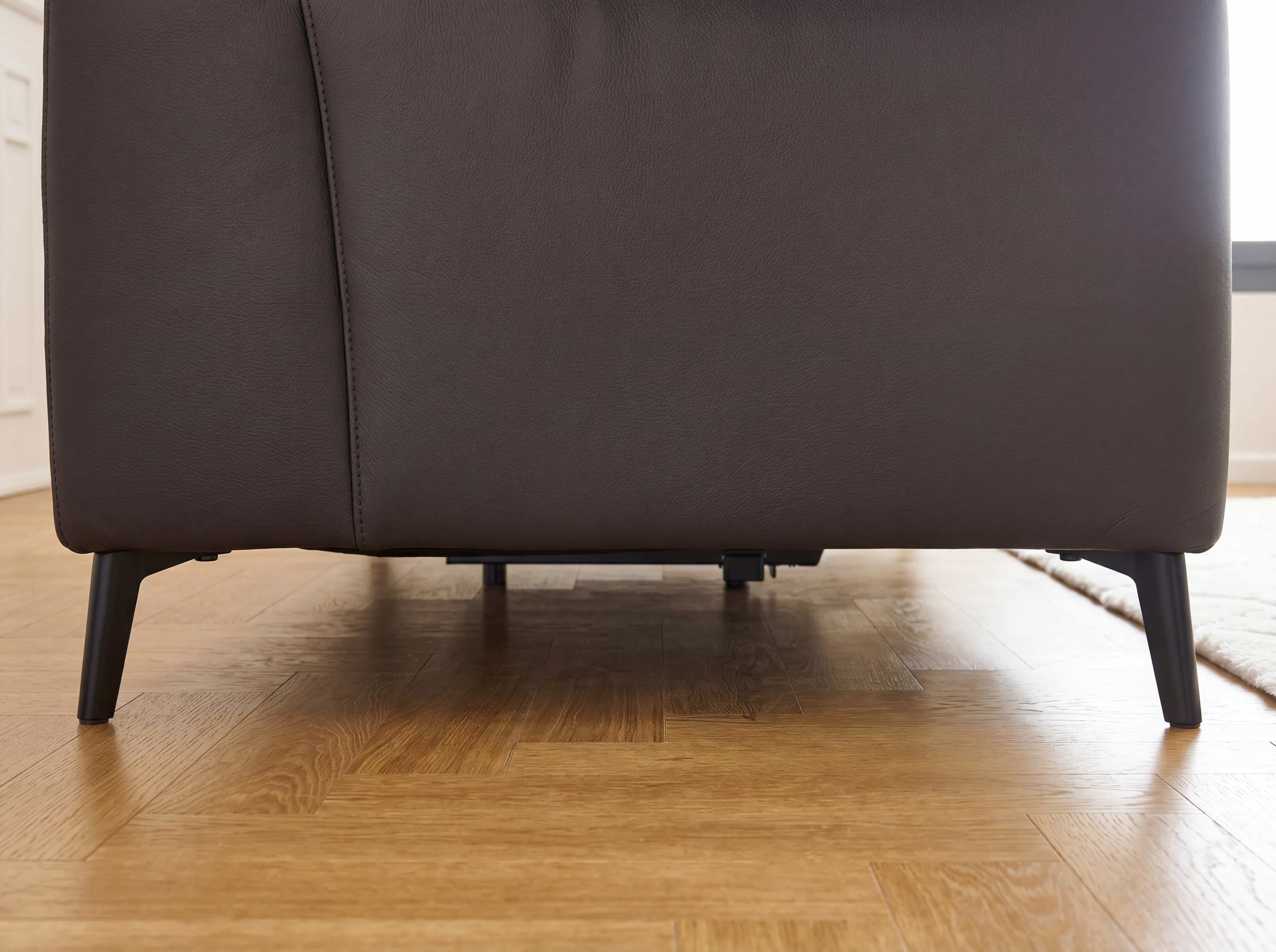 Sofa Kabs Polsterwelt aus braunem Leder mit schwarzem, schräg stehenden Metallgestell, Nahaufnahme