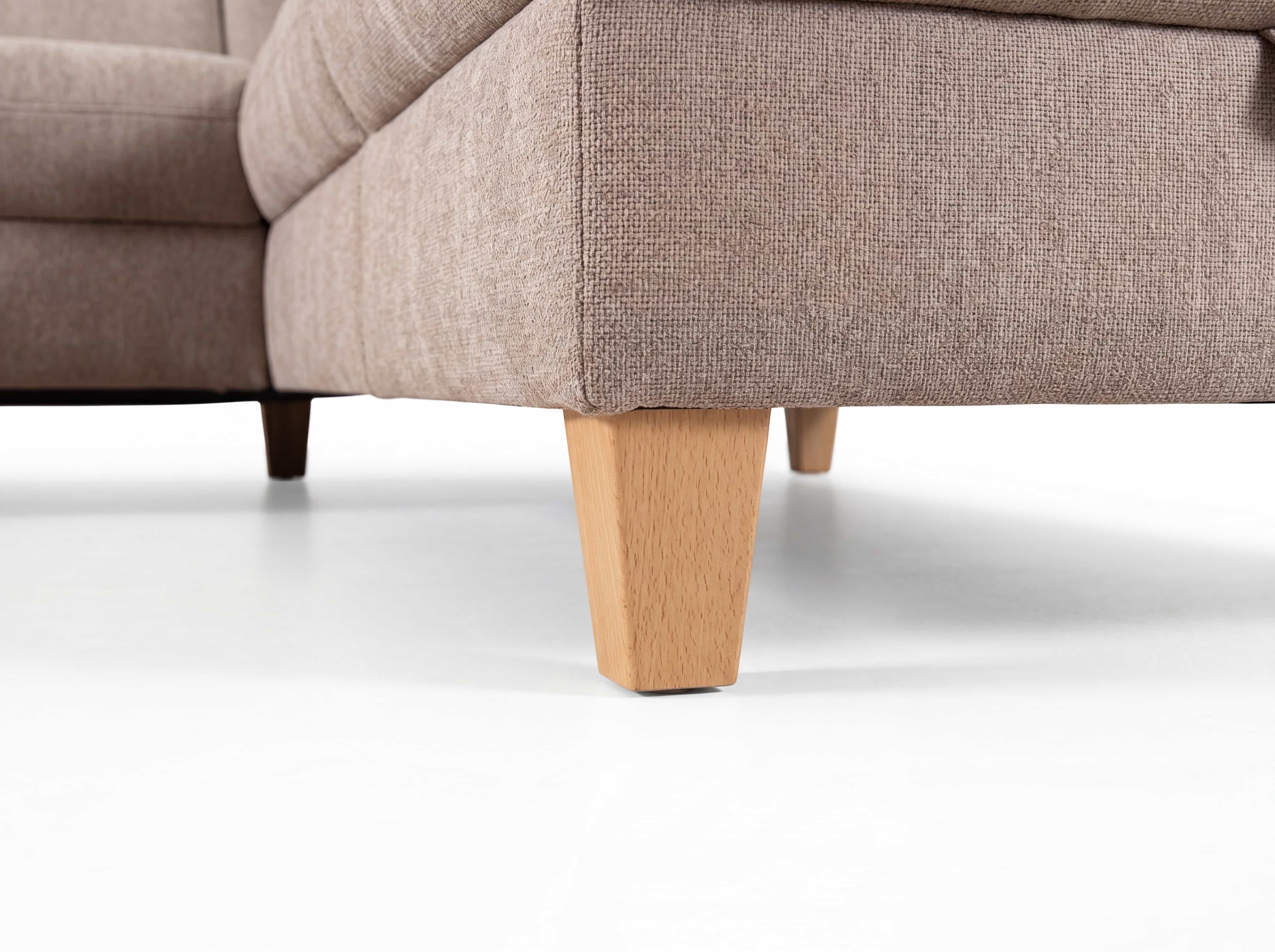 Ecksofa mit beigefarbenem Stoffbezug und konisch zulaufenden Holzfüßen in Naturholzoptik
