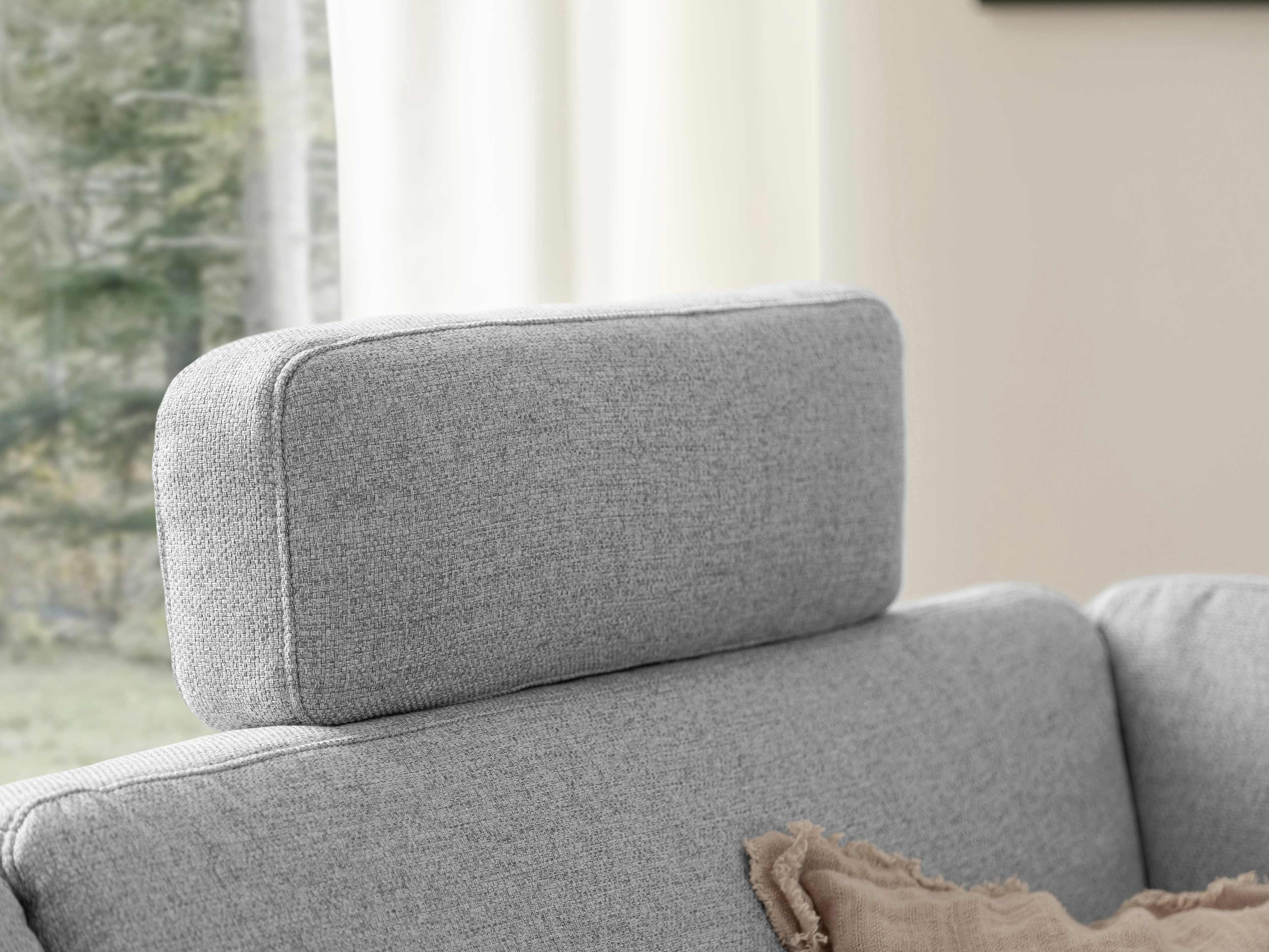 Graues Sofa-Modul mit rechteckiger, gepolsterter Kopfstütze aus Stoffbezug, Nahaufnahme.