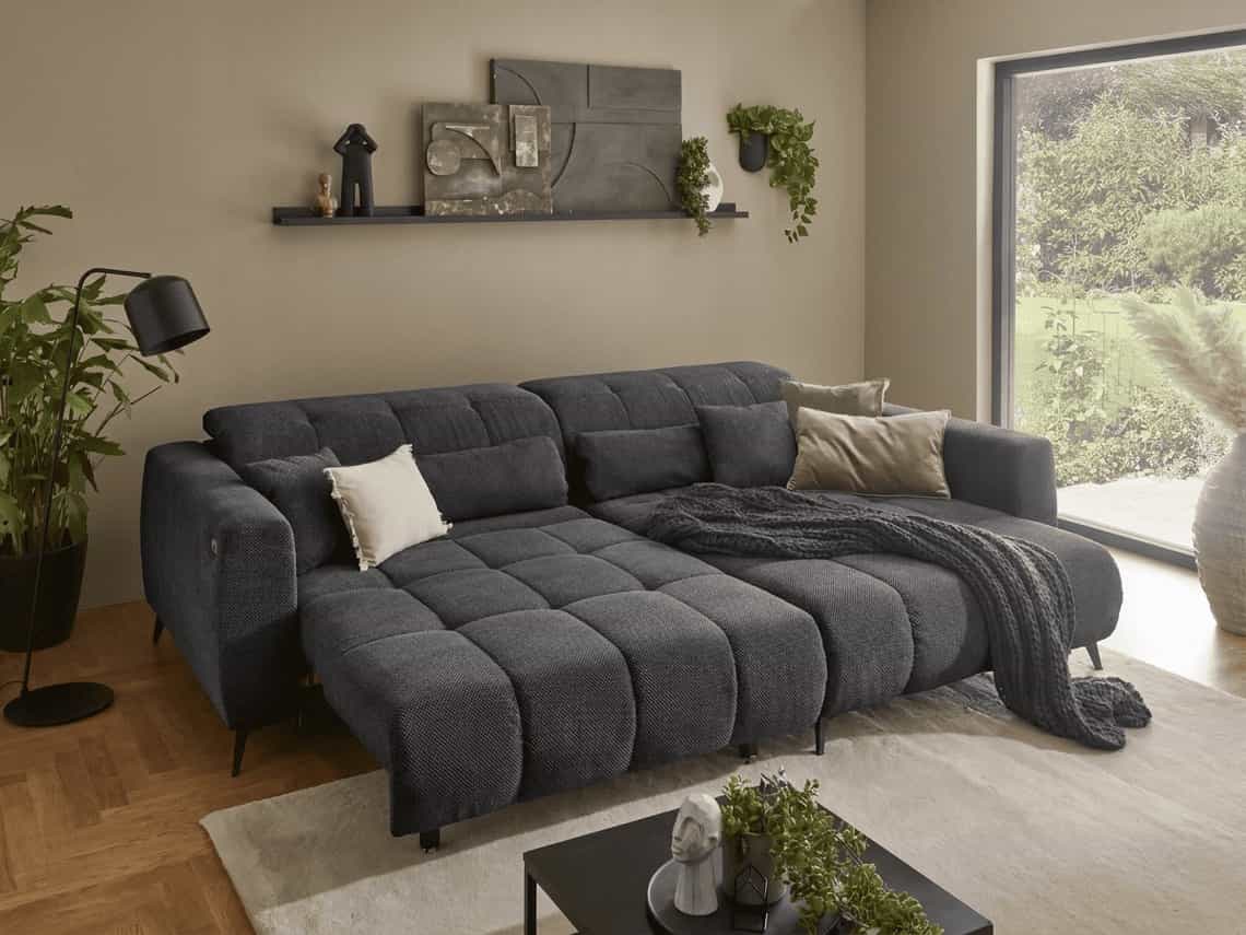 Ecksofa Kabs Polsterwelt mit dunkelgrauem Stoffbezug, breiten Armlehnen und gesteppter Sitzfläche