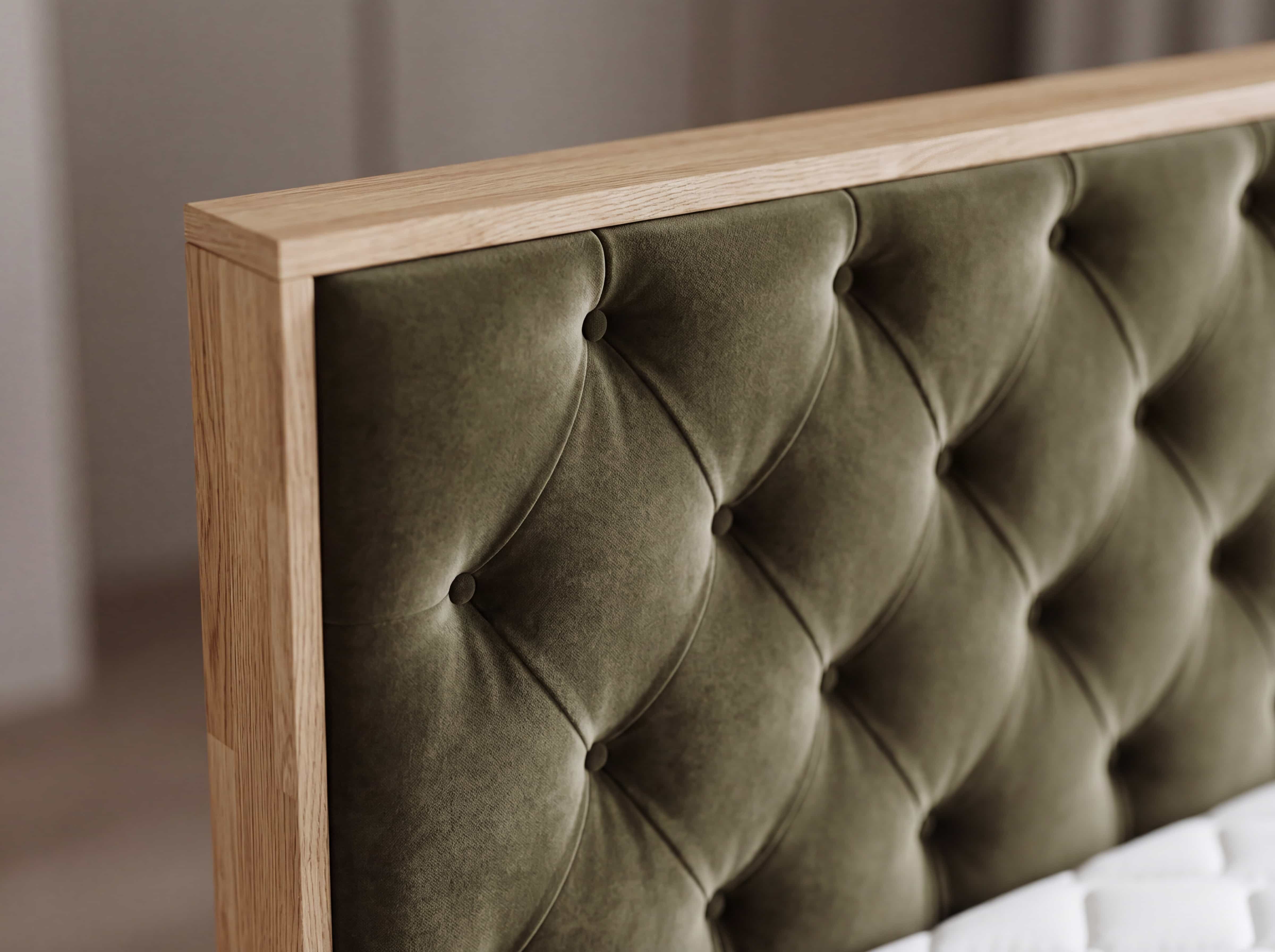 Boxspringbett mit olivgrün gepolstertem Kopfteil, umlaufendem Holzrahmen und Knopfheftung