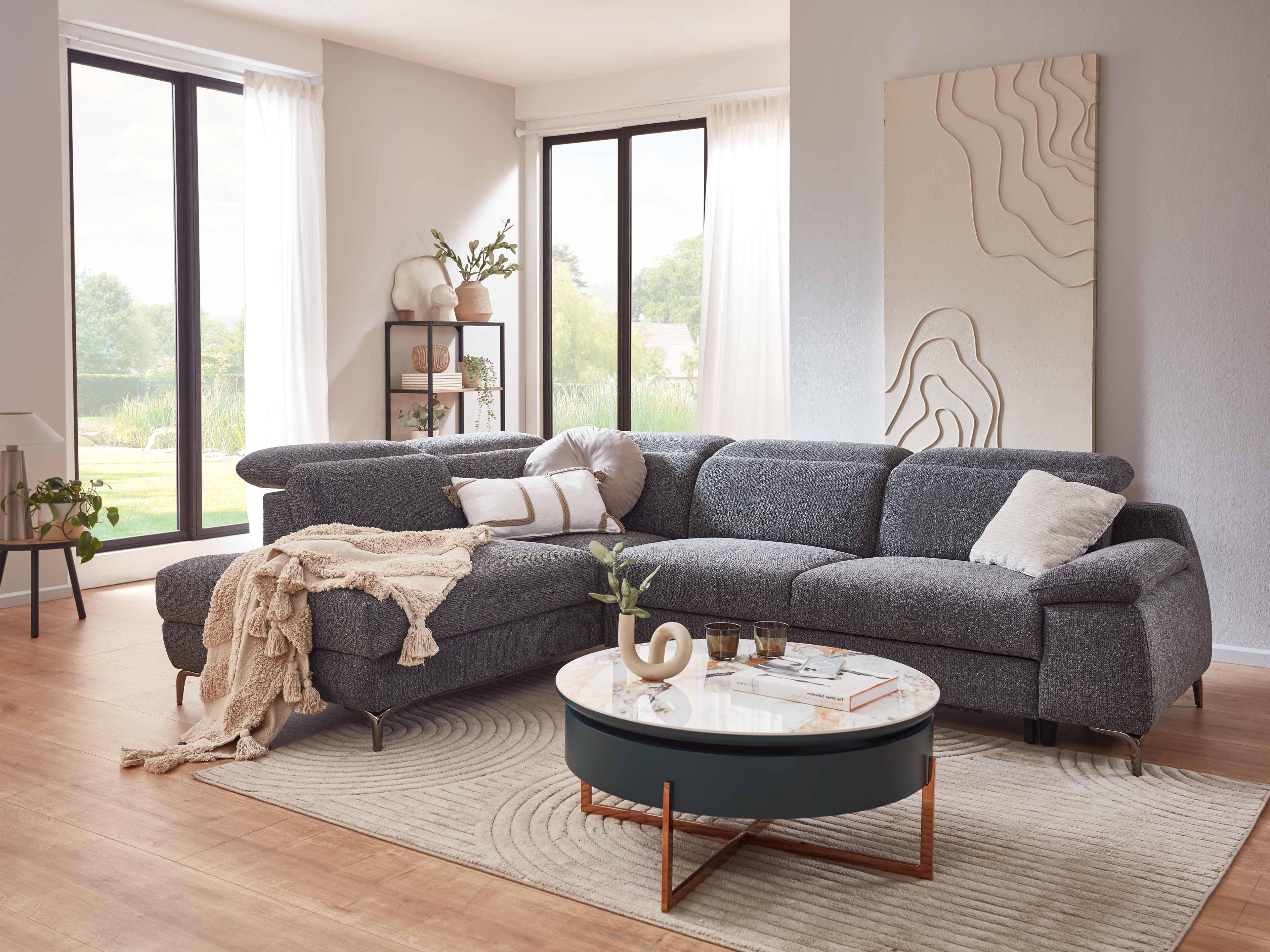 Ecksofa mit dunkelgrauem Stoffbezug, breiten Armlehnen und metallenen Füßen, L-Form