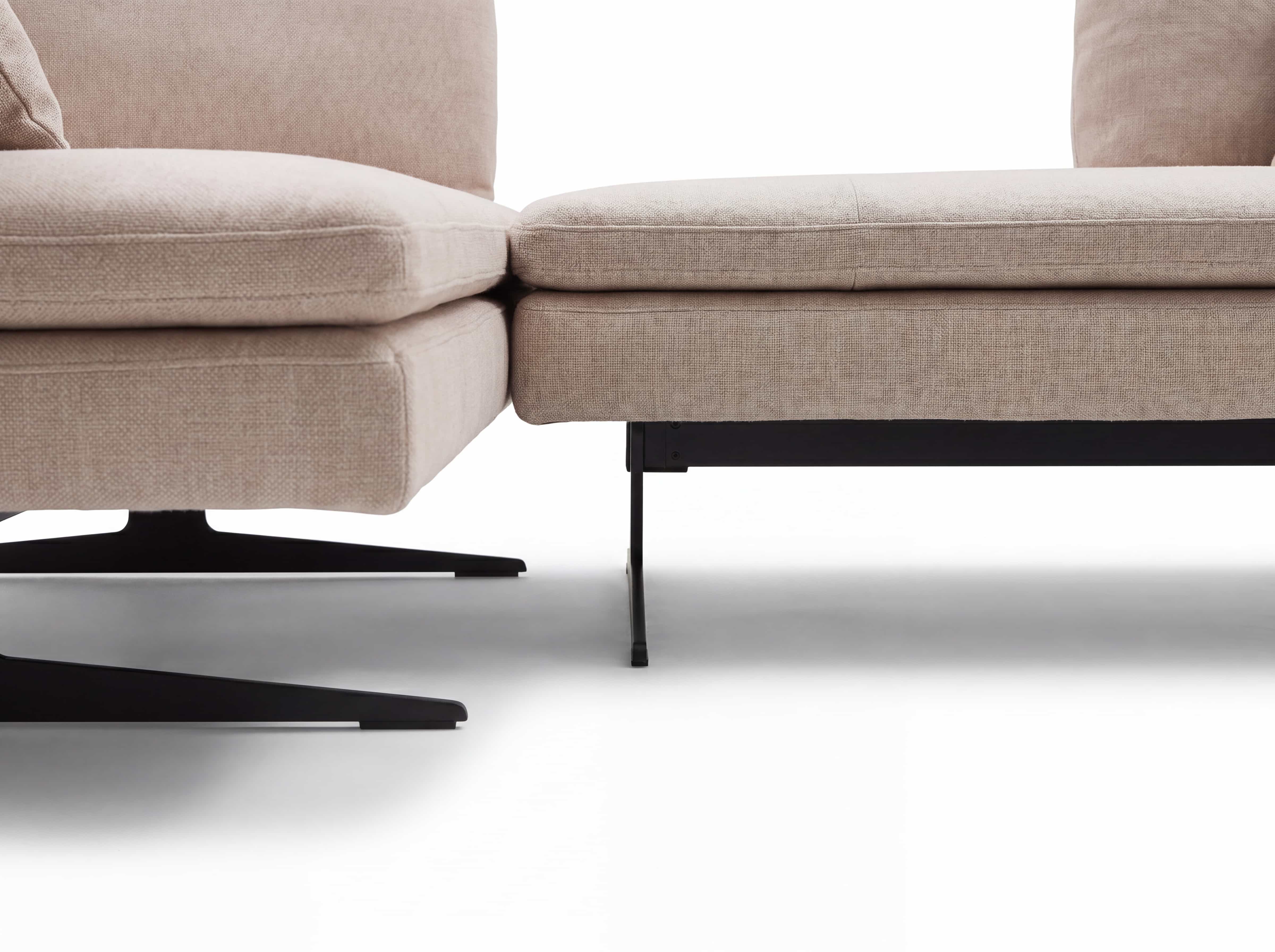 Ecksofa Modell mit beigem Stoffbezug, gepolsterten Sitzflächen und schwarzen Metallfüßen