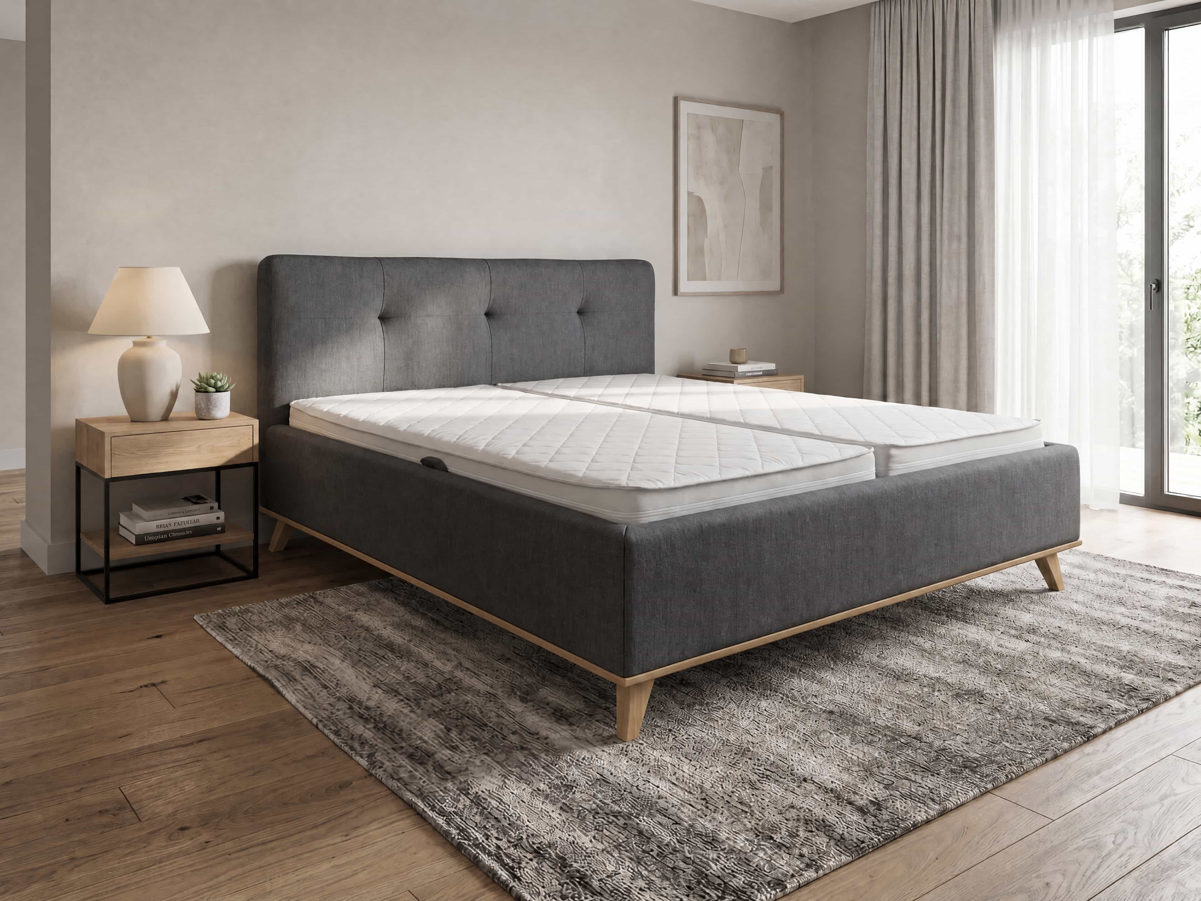 Polsterbett mit grau gepolstertem Kopfteil, Holzfüßen und sichtbarer Steppung im modernen Design