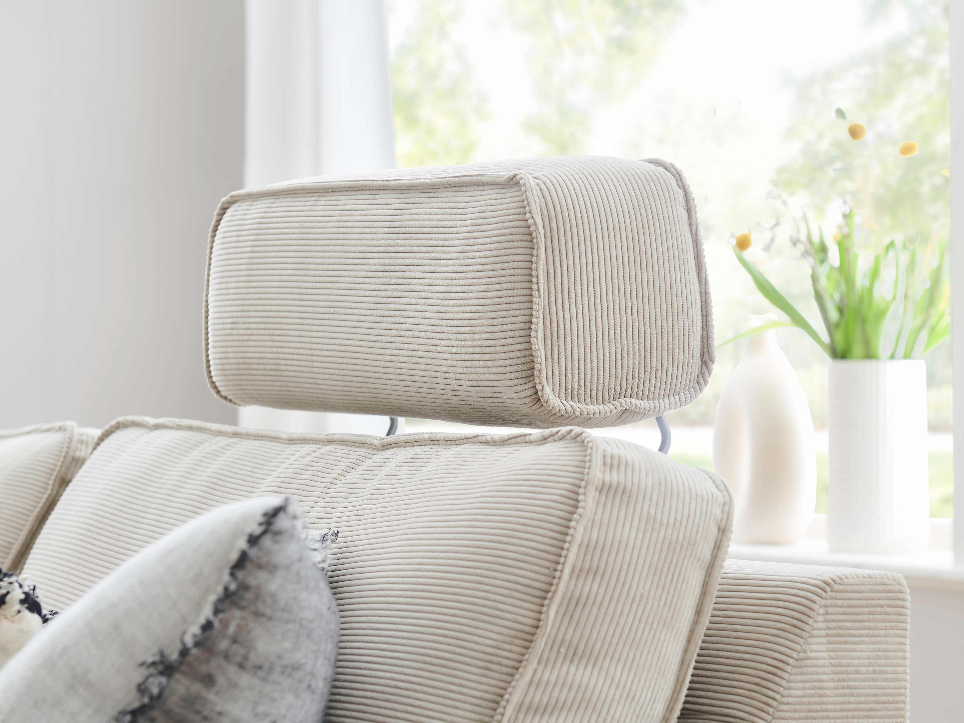 Kopfstütze aus beigefarbenem Cordstoff an Polstersofa, sichtbar strukturierte Oberfläche