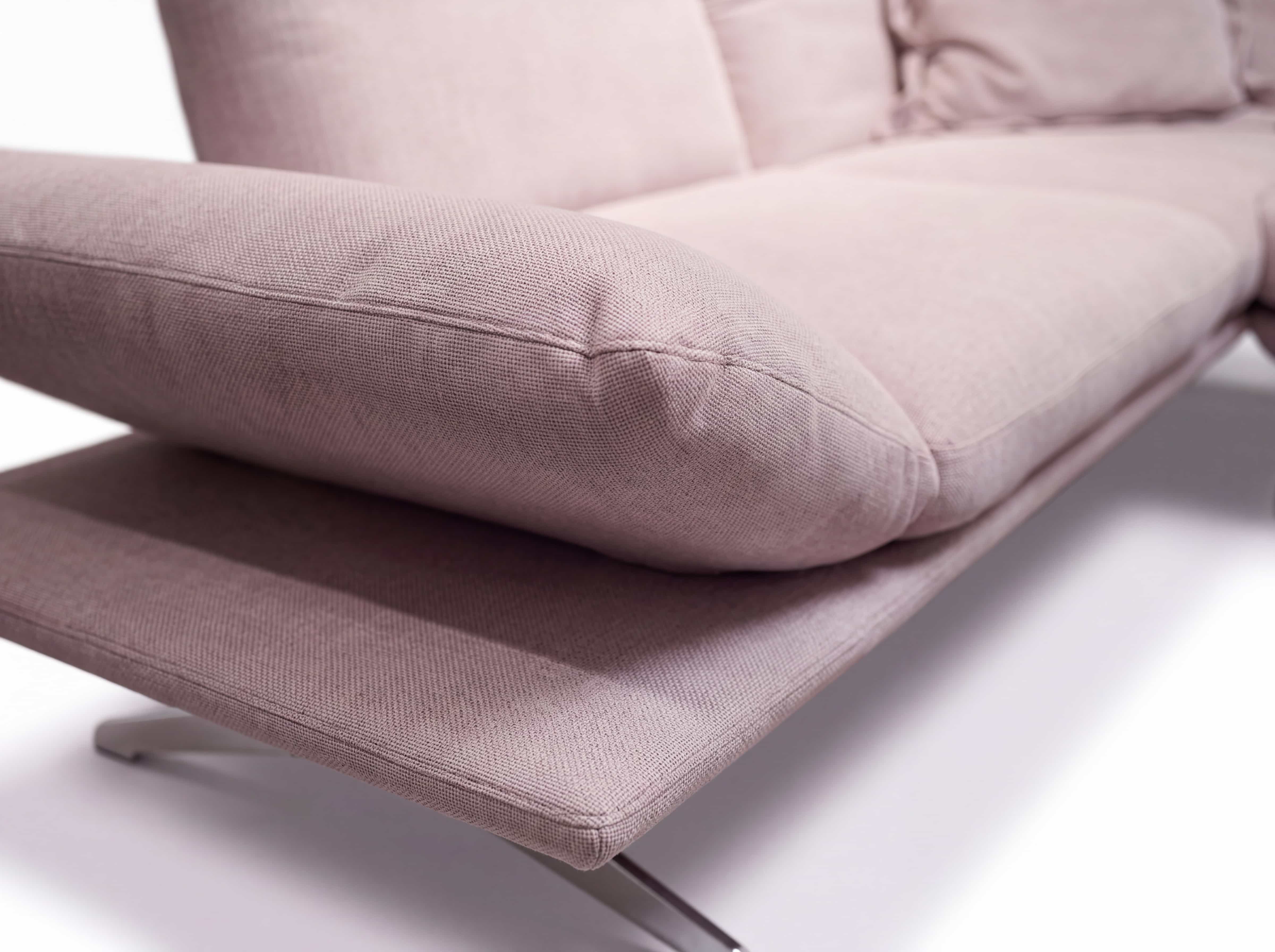 Ecksofa Kabs mit rosa Stoffbezug, gepolsterter Armlehne und Metallfüßen in Nahaufnahme