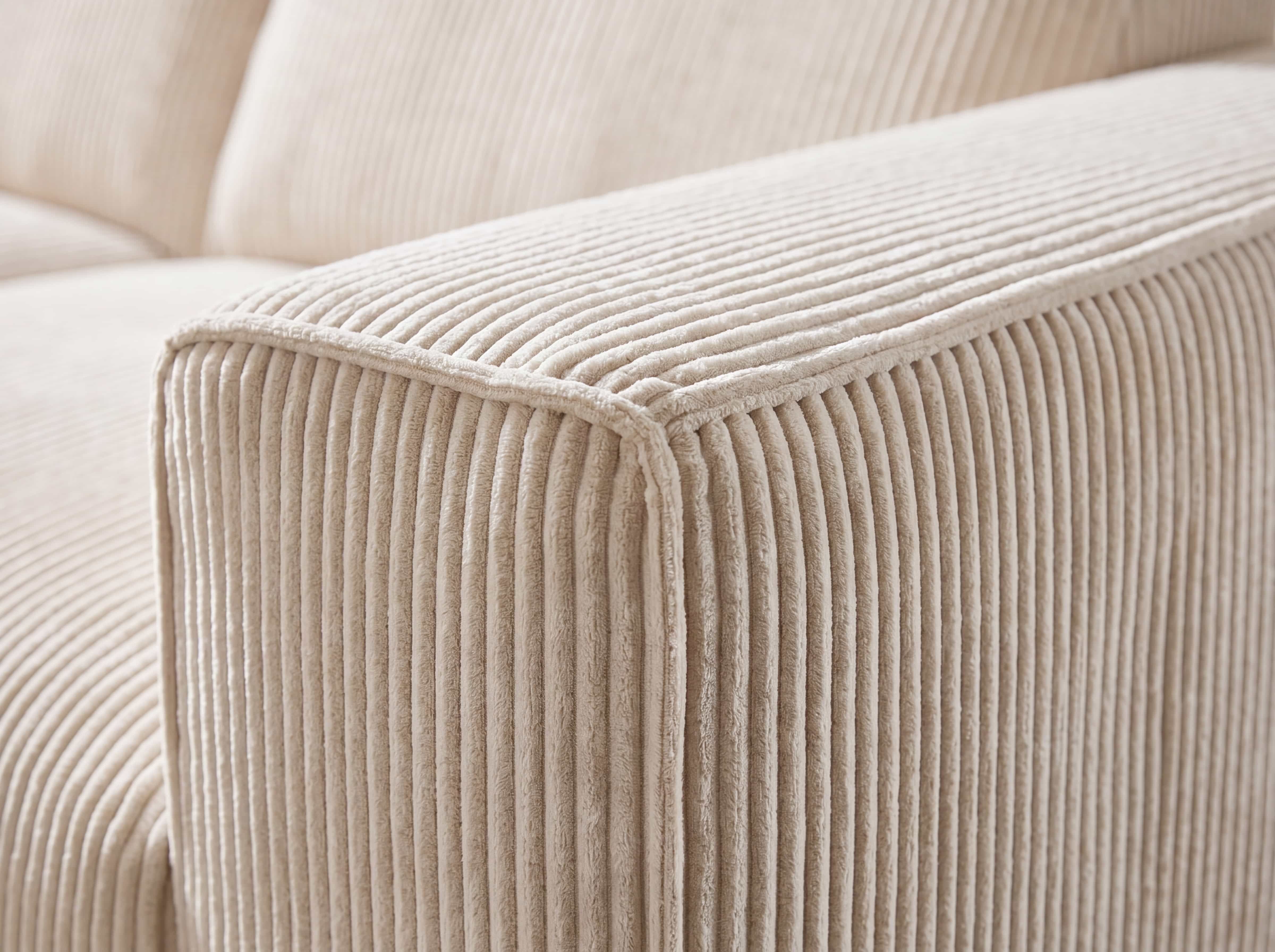 Ecksofa mit breiter Armlehne aus beigefarbenem Cordstoff und markanter Rillenstruktur