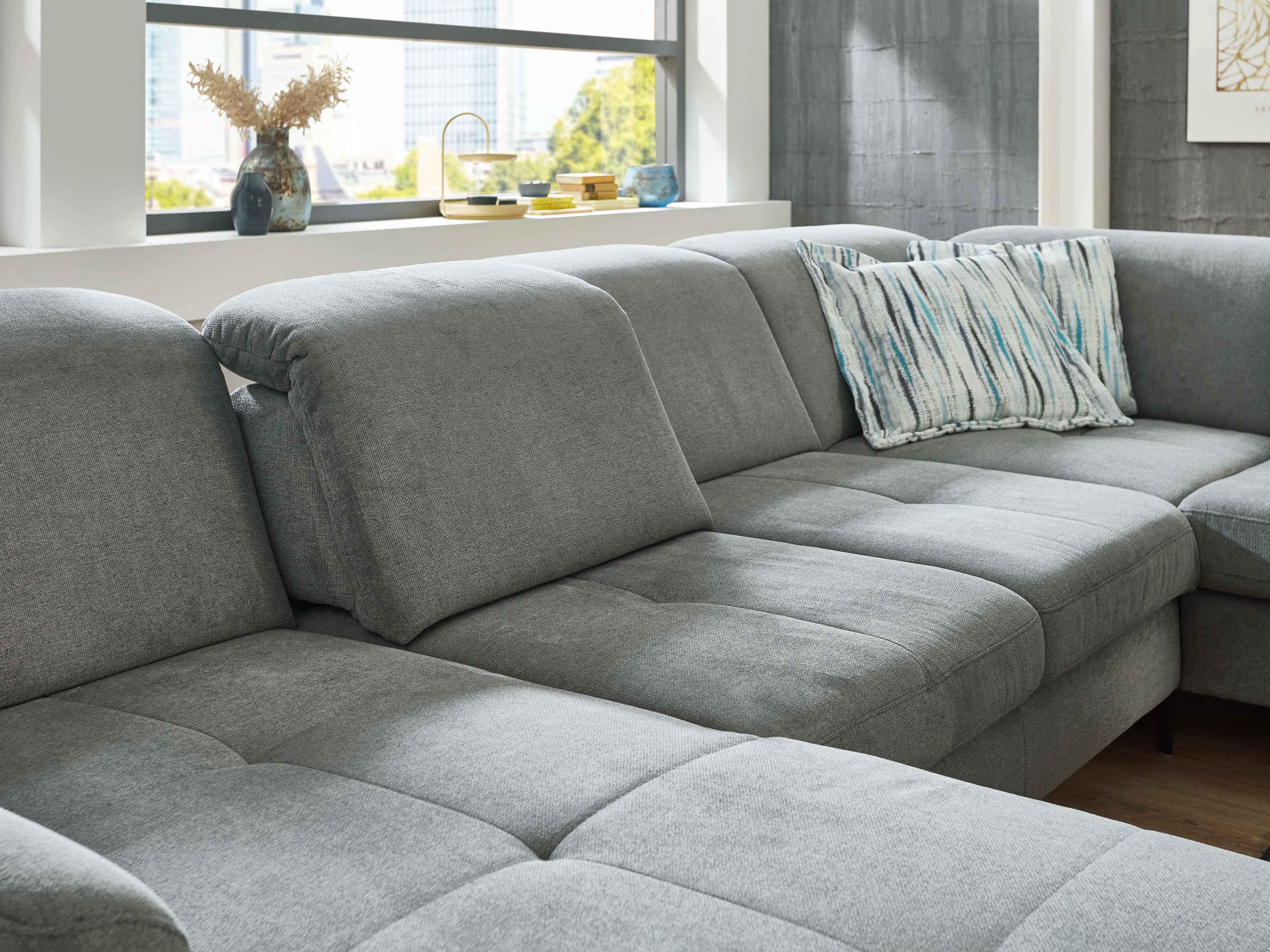 Ecksofa Kabs Polsterwelt mit grauem Stoffbezug, gepolsterter Rückenlehne und verstellbaren Kopfstützen