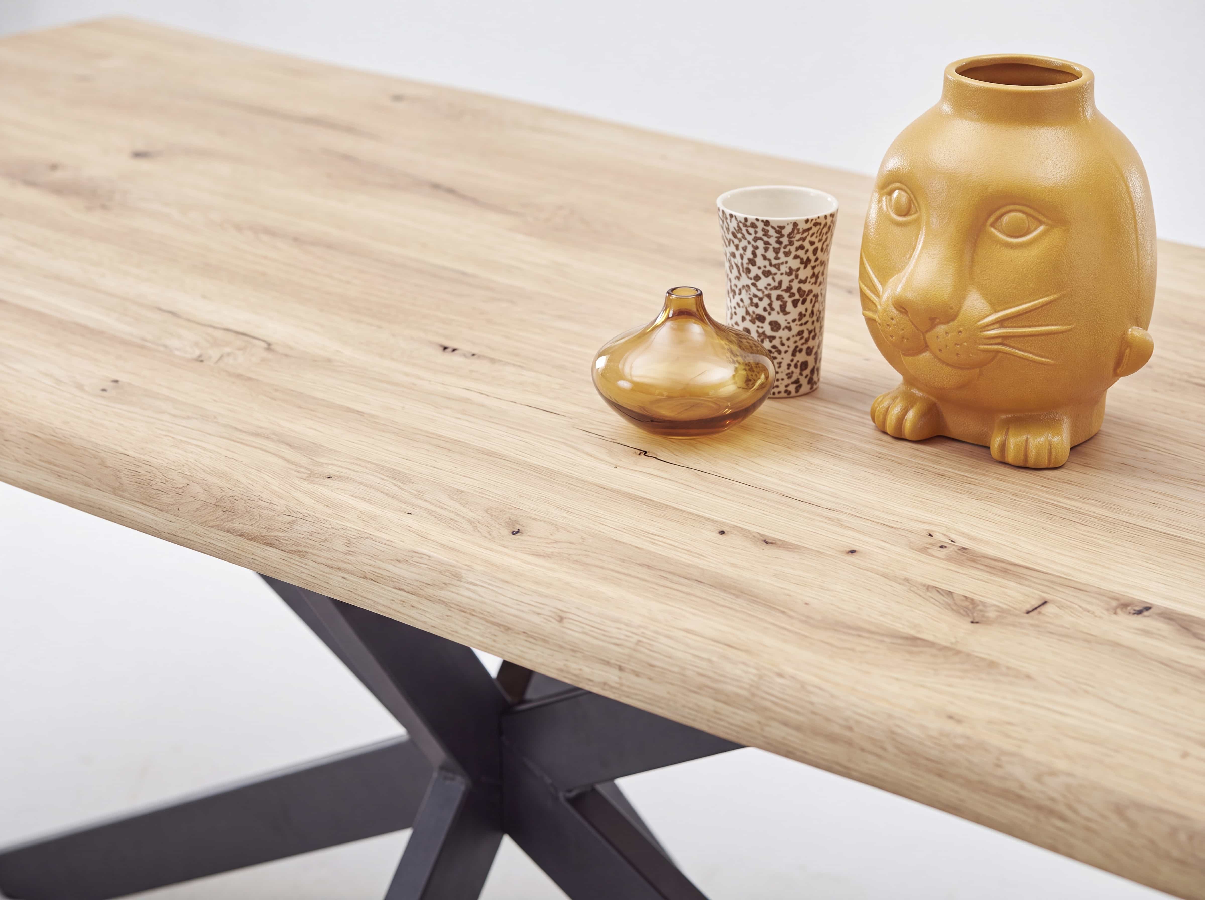 Esstisch mit rechteckiger Tischplatte aus hellen Holz, schwarzem Metallgestell und Dekoration