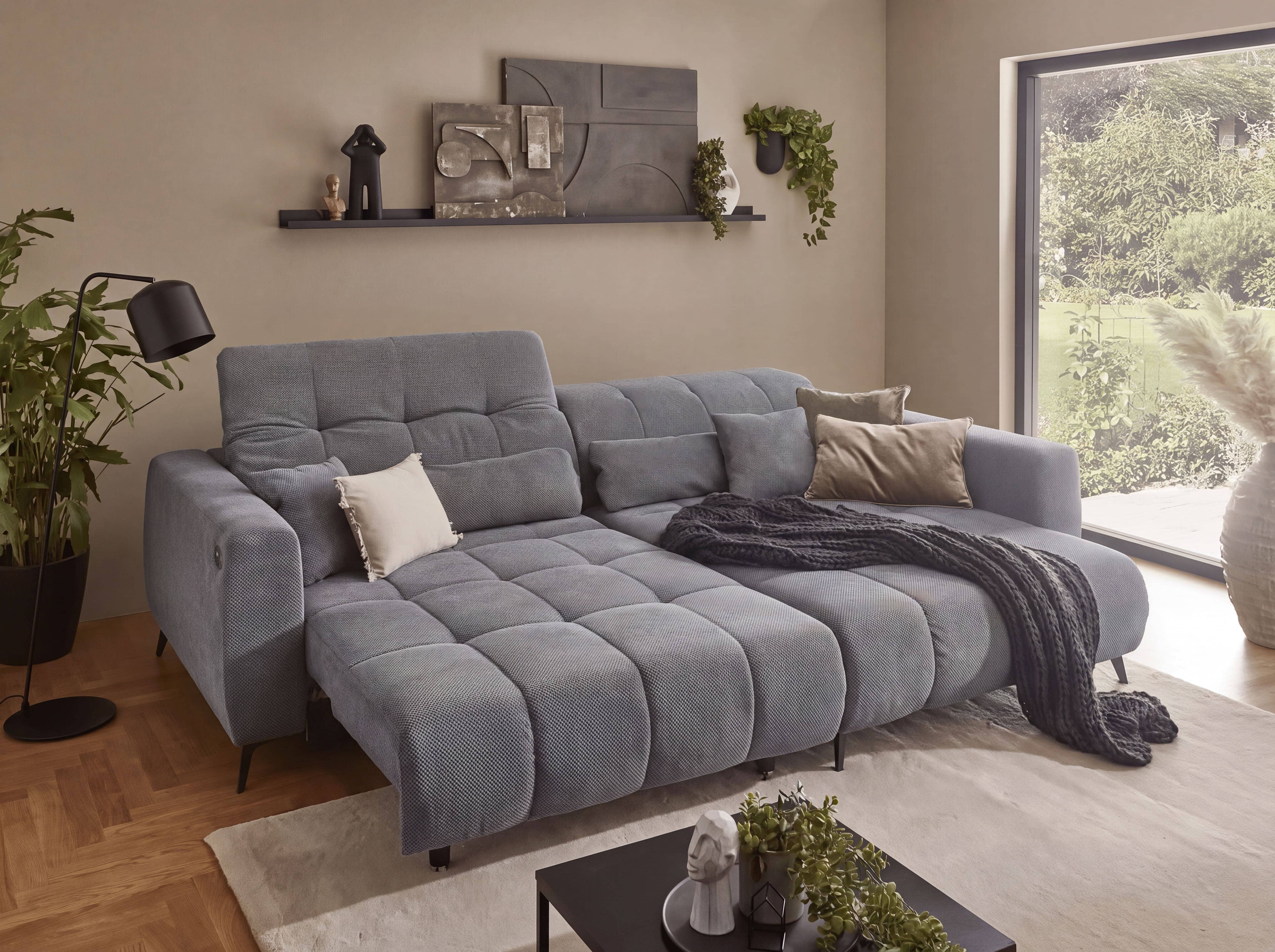 Ecksofa Kabs mit grauem Stoffbezug, Steppung, breiten Armlehnen und verstellbaren Rückenlehnen