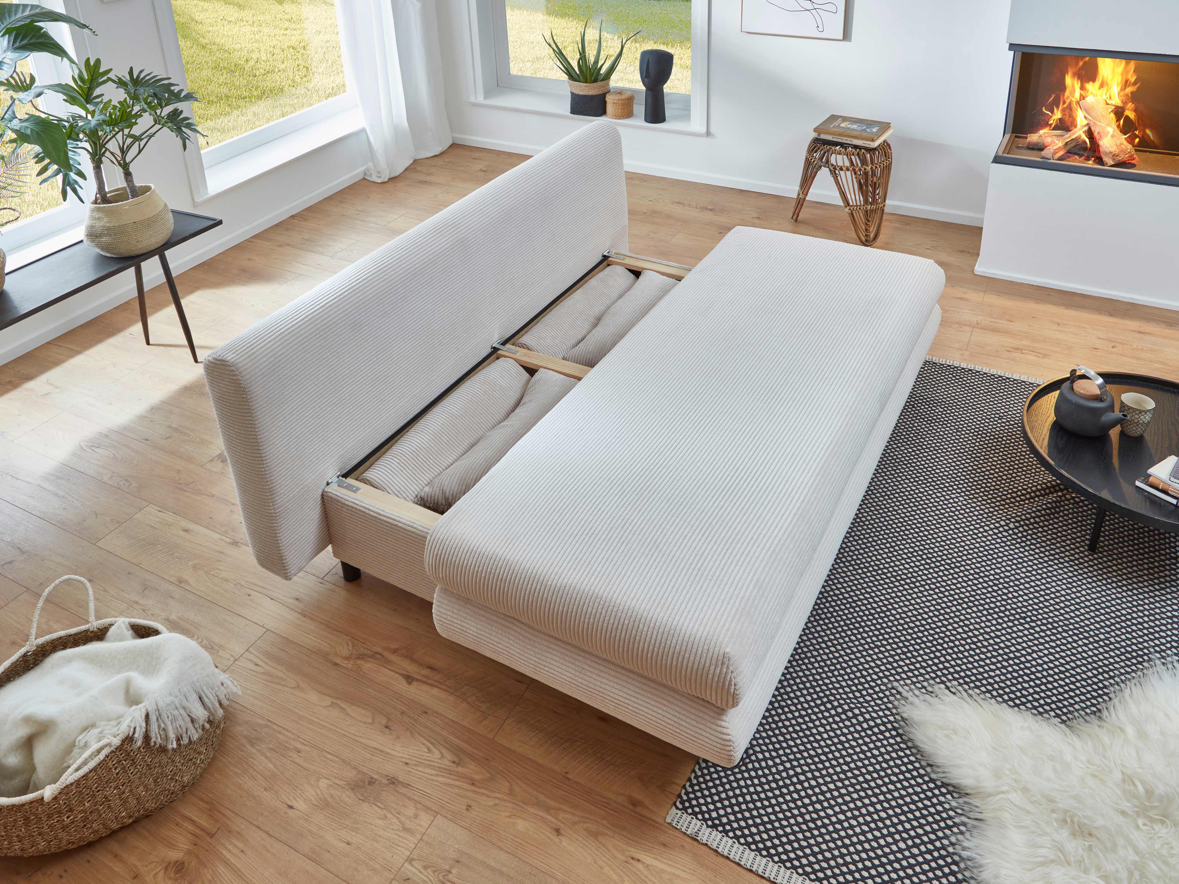 Schlafsofa mit beigefarbenem Cordbezug, ausgeklappt mit sichtbarem Holzrahmen und geraden Armlehnen