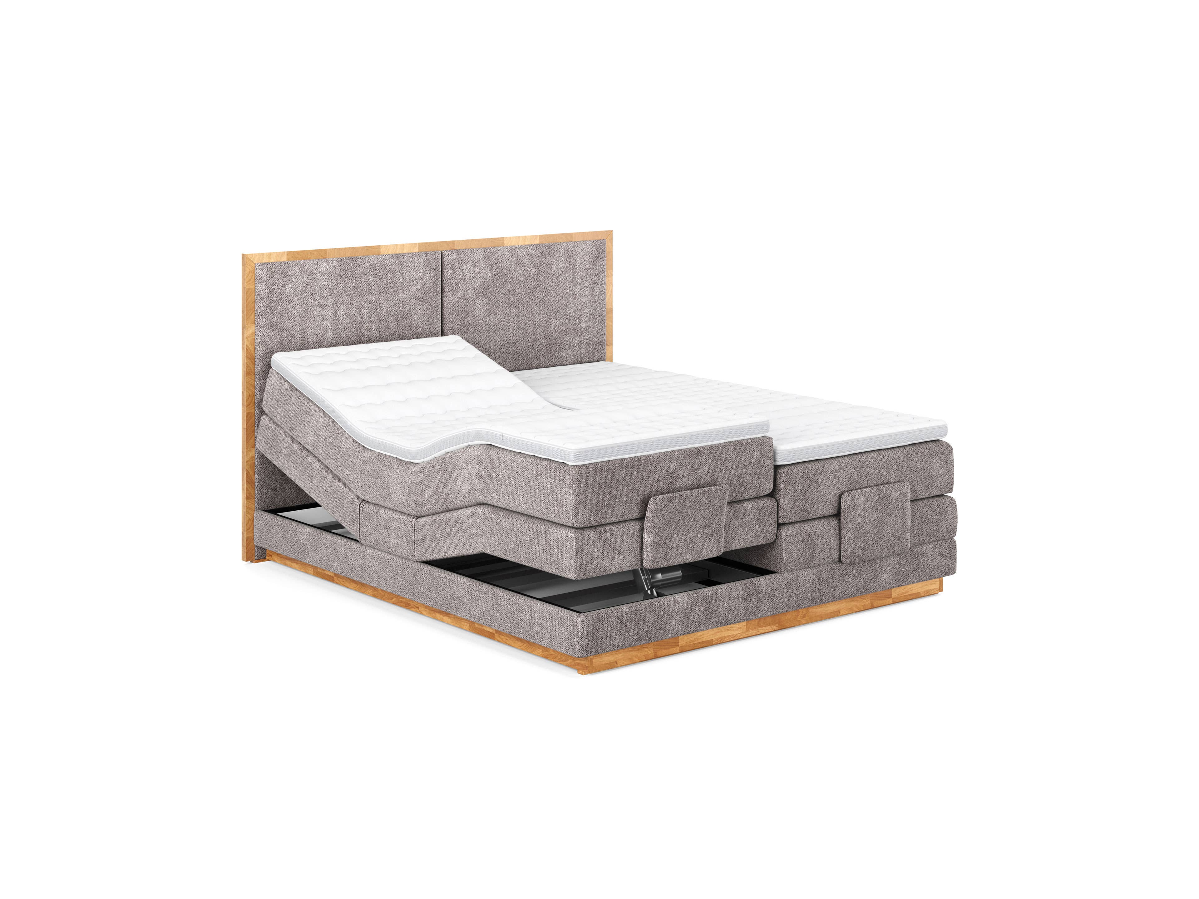 Boxspringbett mit hellgrauem Stoffbezug, gepolstertem Kopfteil und sichtbaren Holzrahmen, verstellbar