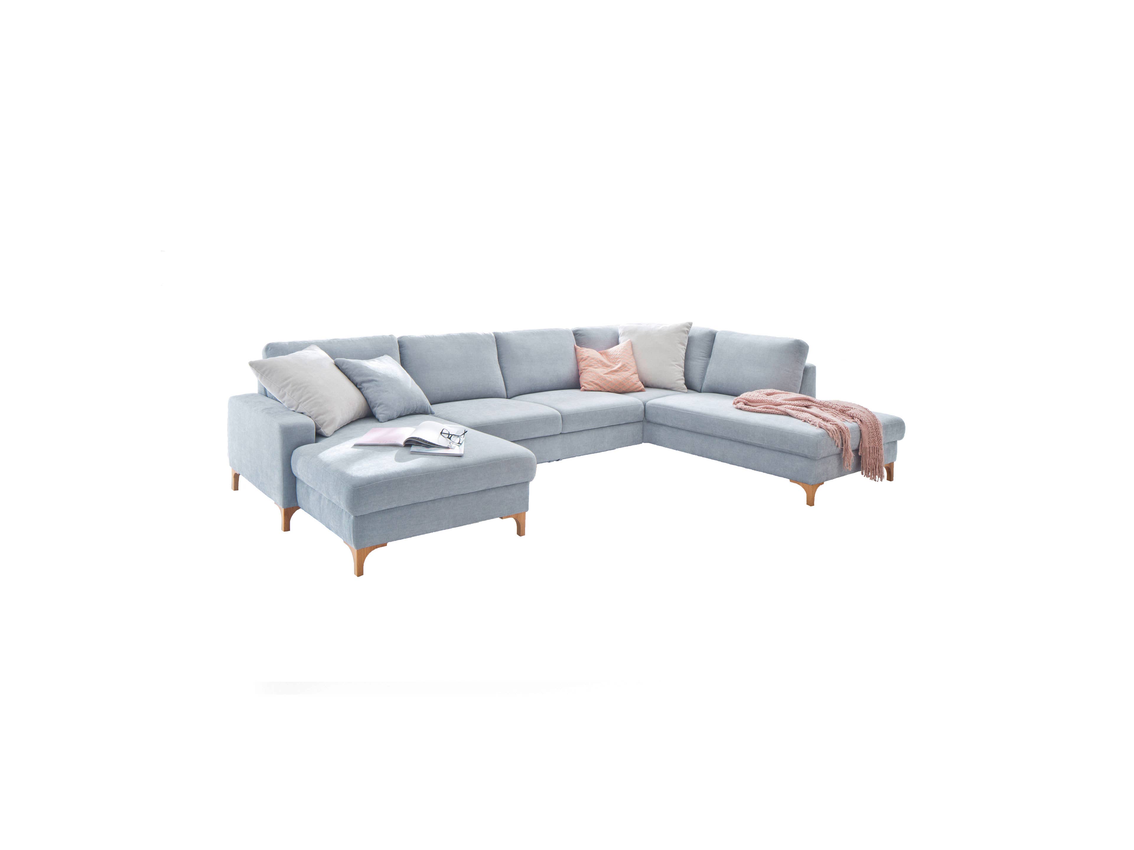 Ecksofa Kabs Polsterwelt mit hellblauem Stoffbezug, Holzfüßen, Armlehnen und loser Kissenanordnung