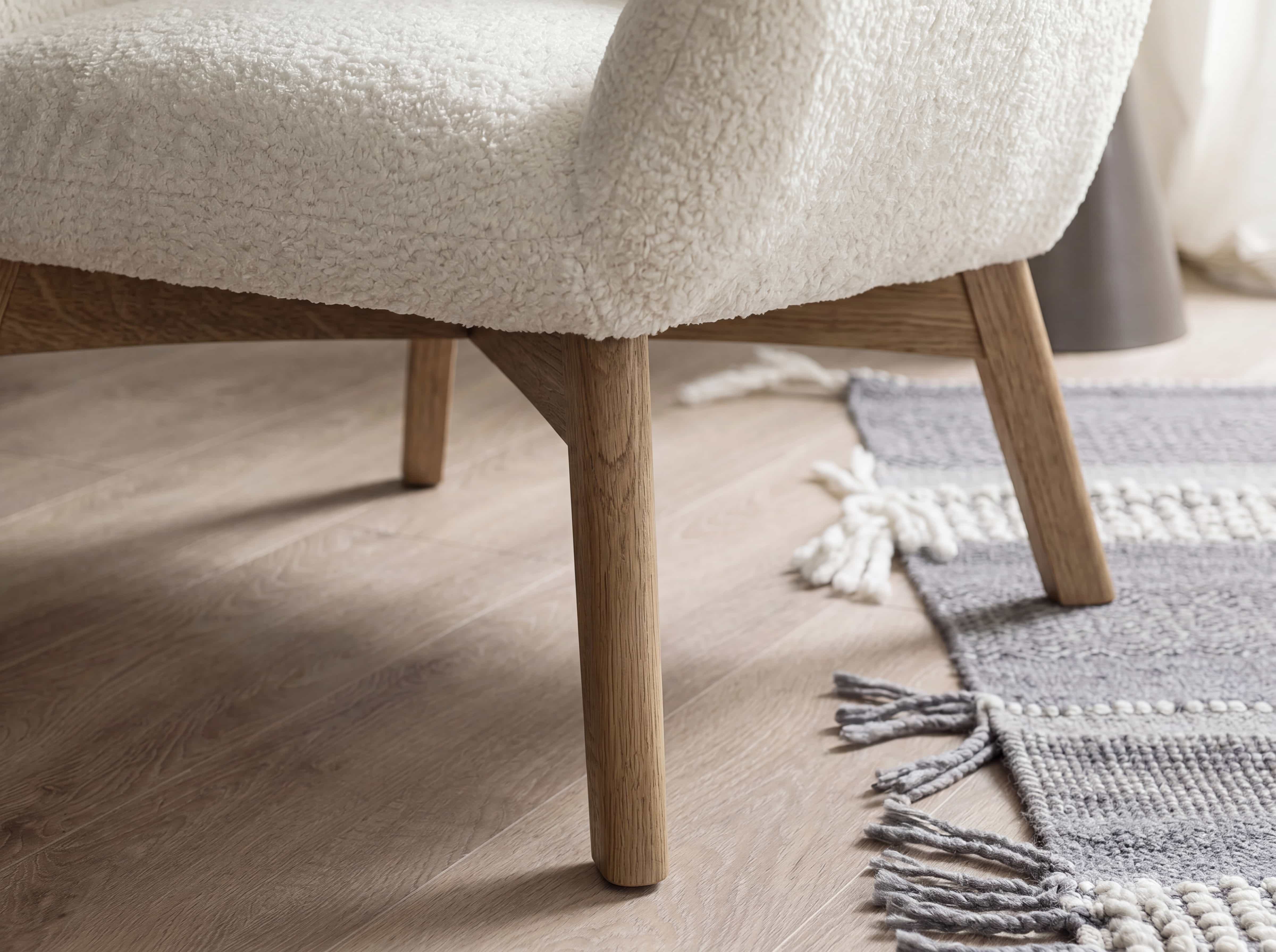 Esszimmerstuhl mit Sitzfläche aus weißem Bouclé-Stoff und schrägen Beinen aus hellem Holz