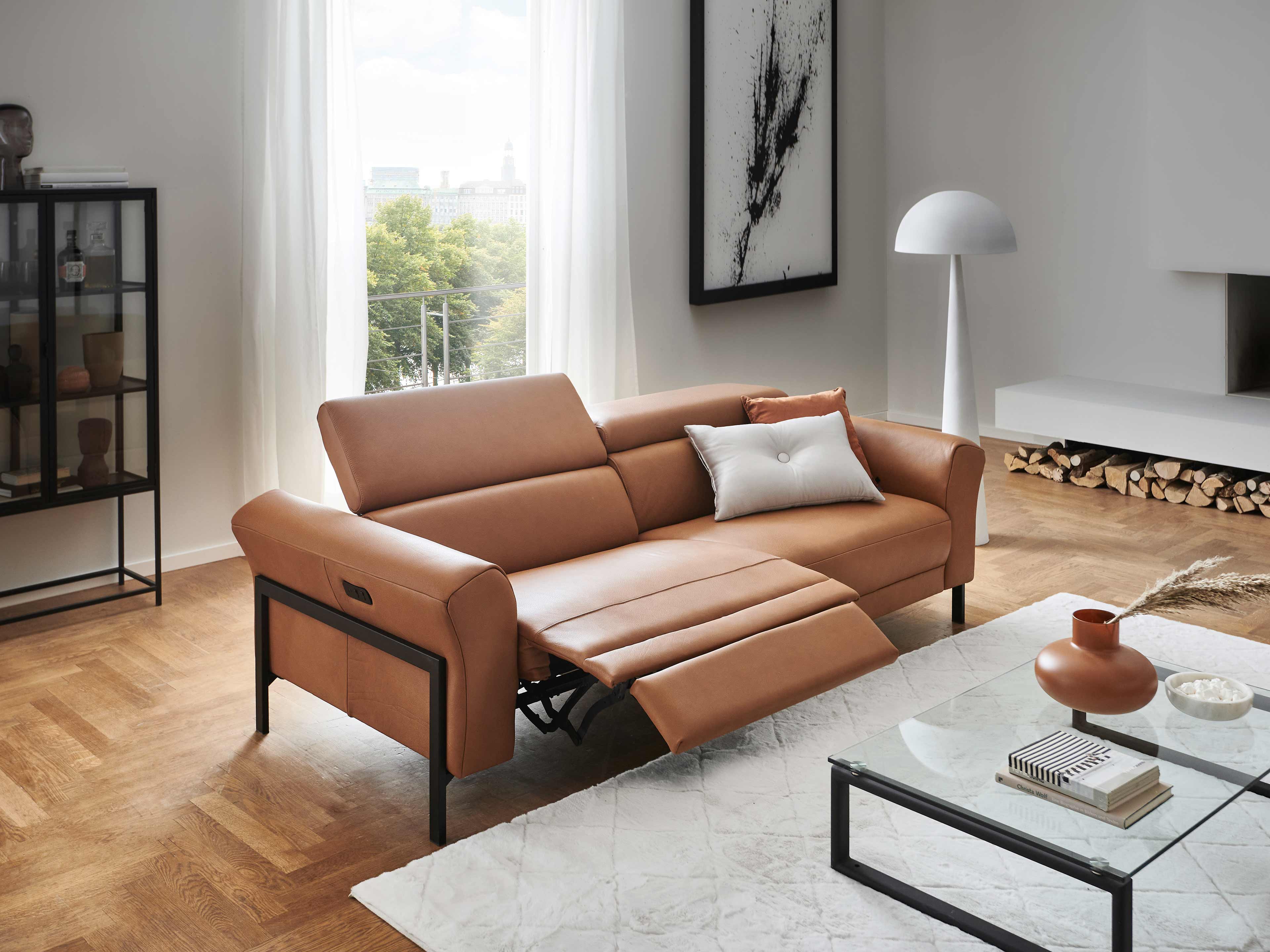 2-Sitzer Sofa Manhattan aus cognacfarbenem Leder mit schwarzen Metallfüßen und verstellbarer Fußstütze