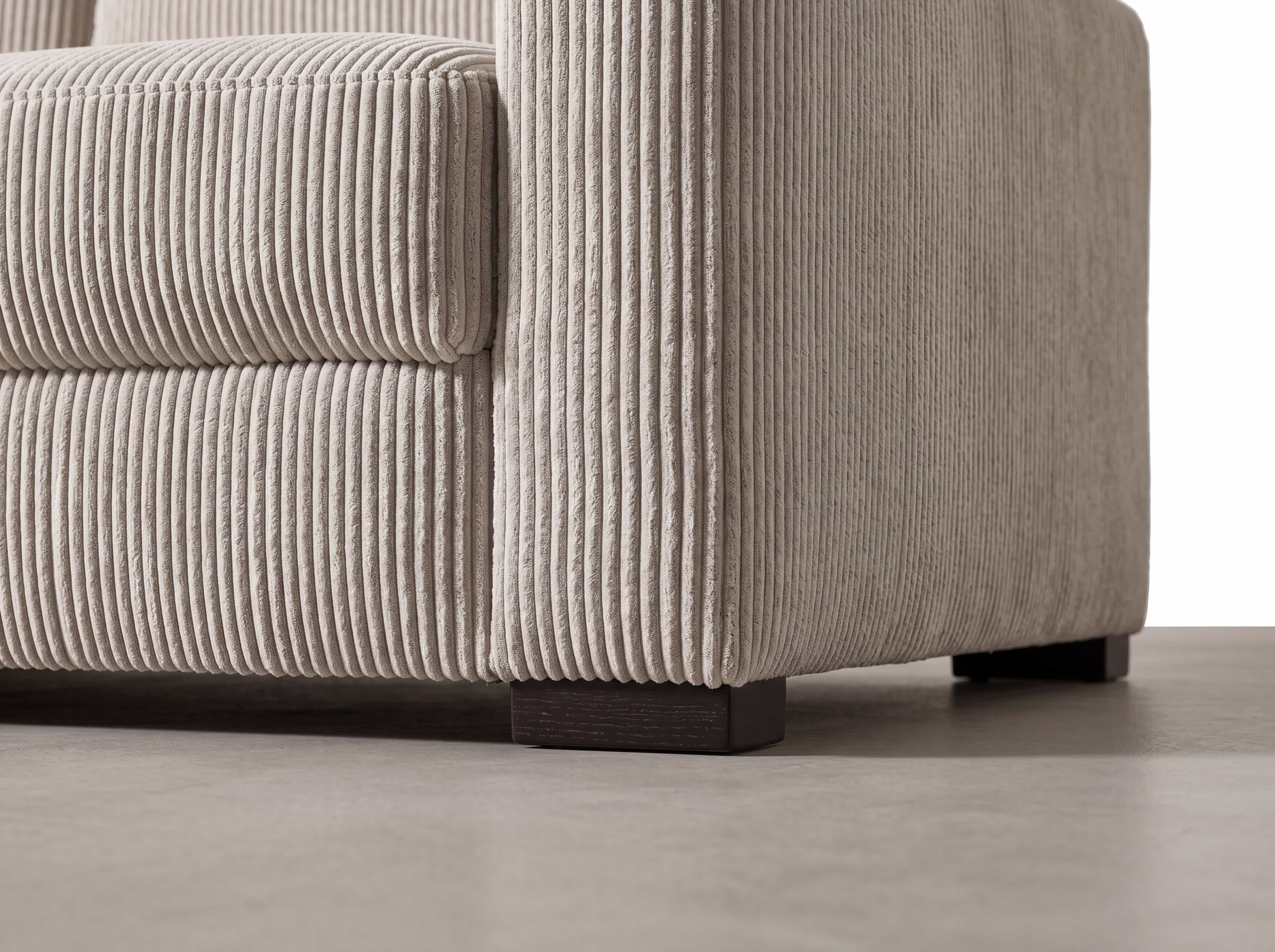 Ecksofa Cordius mit beigem Cordbezug, breiten Armlehnen und dunklen, niedrigen eckigen Füßen