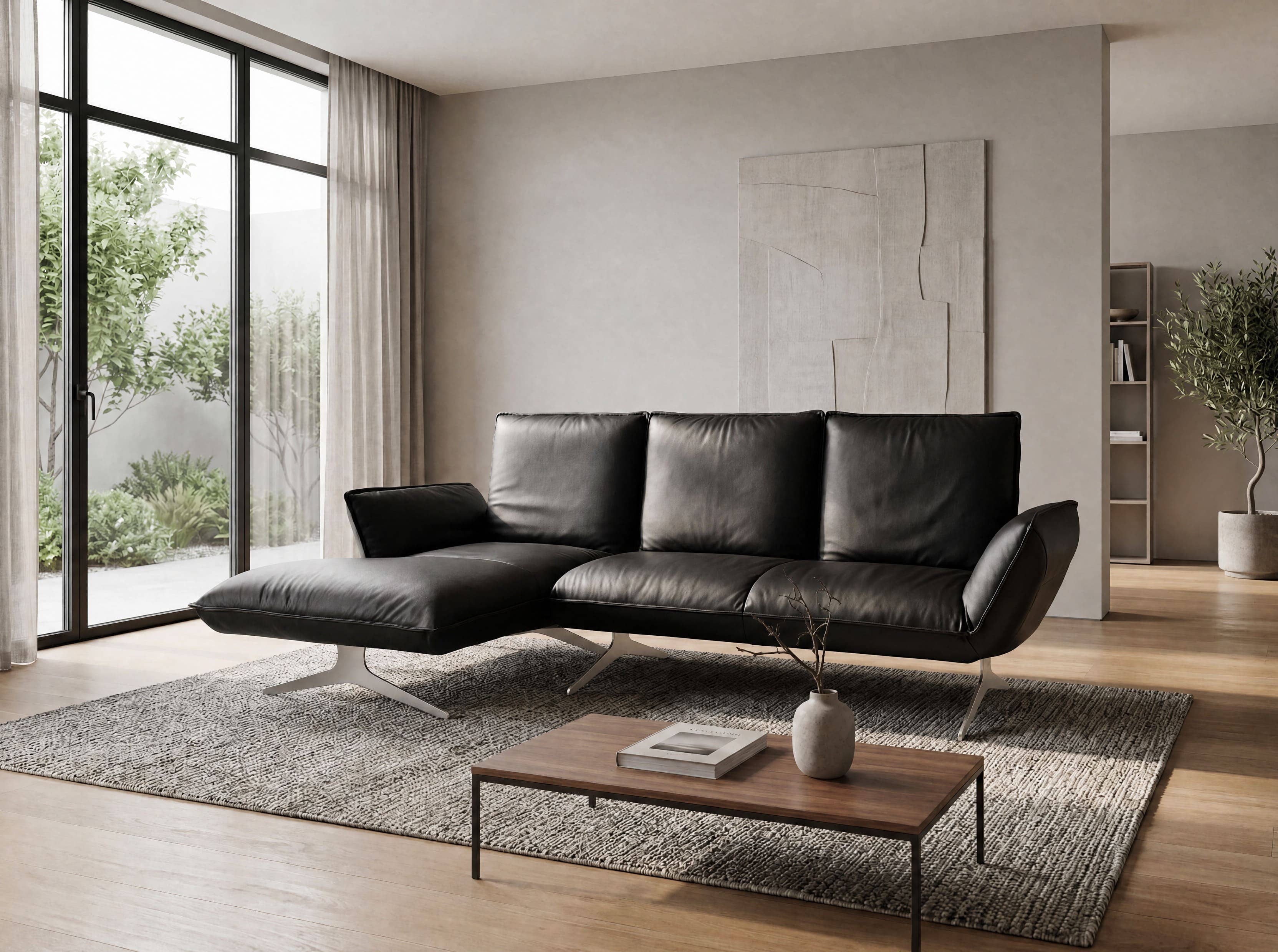 Ecksofa Kabs mit schwarzem Lederbezug, breiten Armlehnen und Metallfüßen auf Teppich