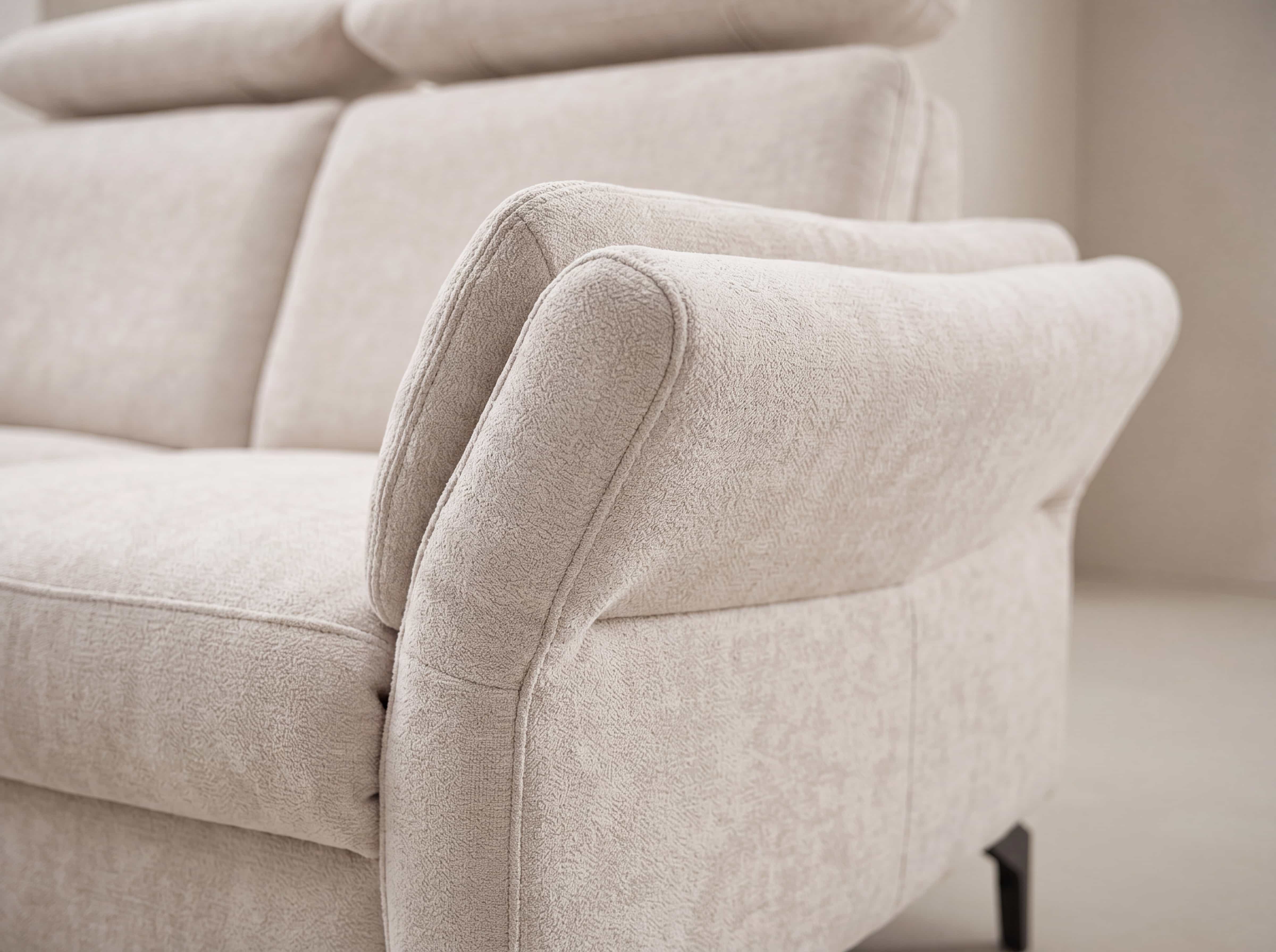 Ecksofa mit beigem Stoffbezug, gepolsterter Rückenlehne und weich gerundeten Armlehnen