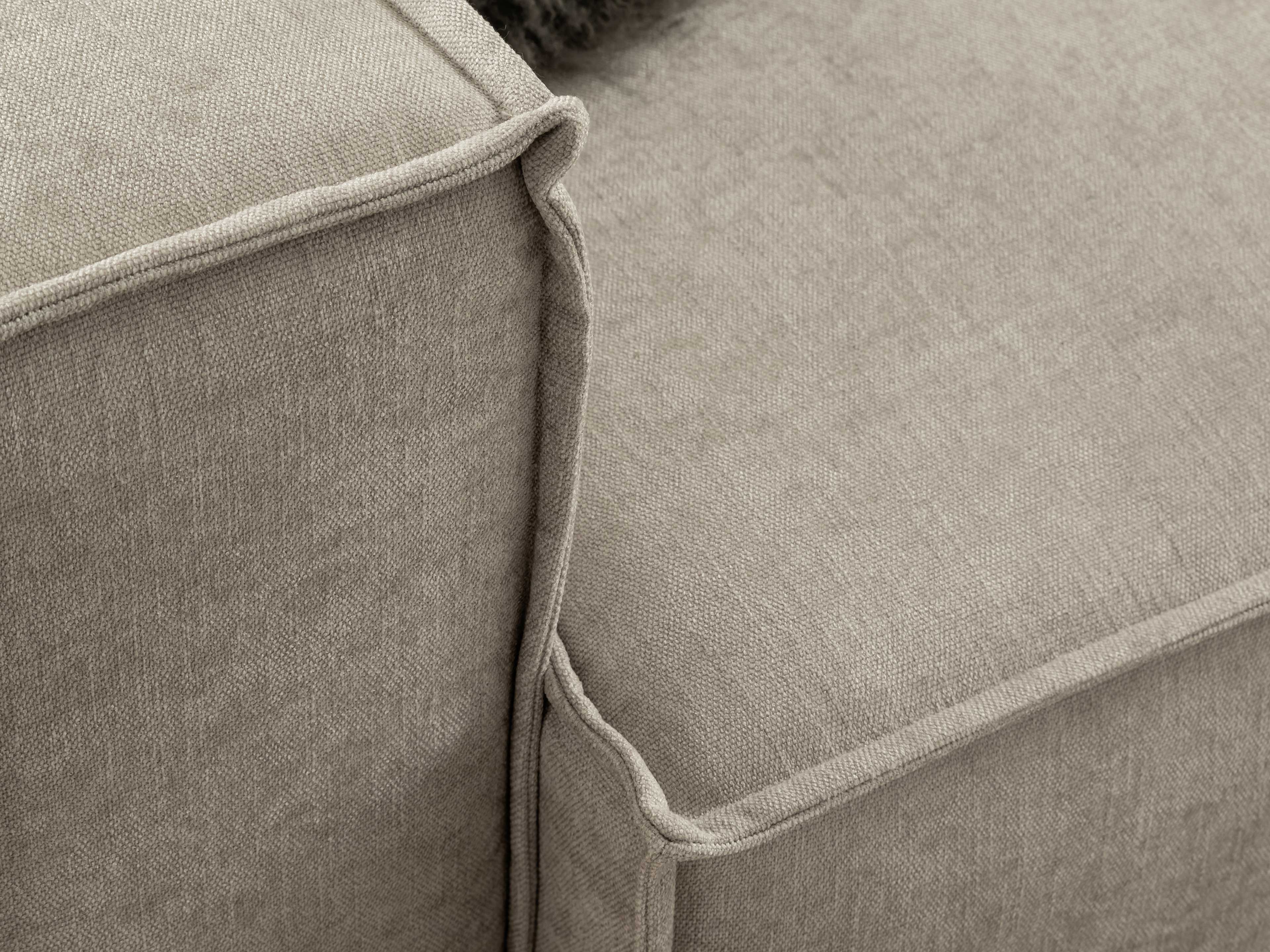 Detailaufnahme eines Sofas mit beigem Stoffbezug und sichtbarer Kante mit umlaufender Paspelnaht