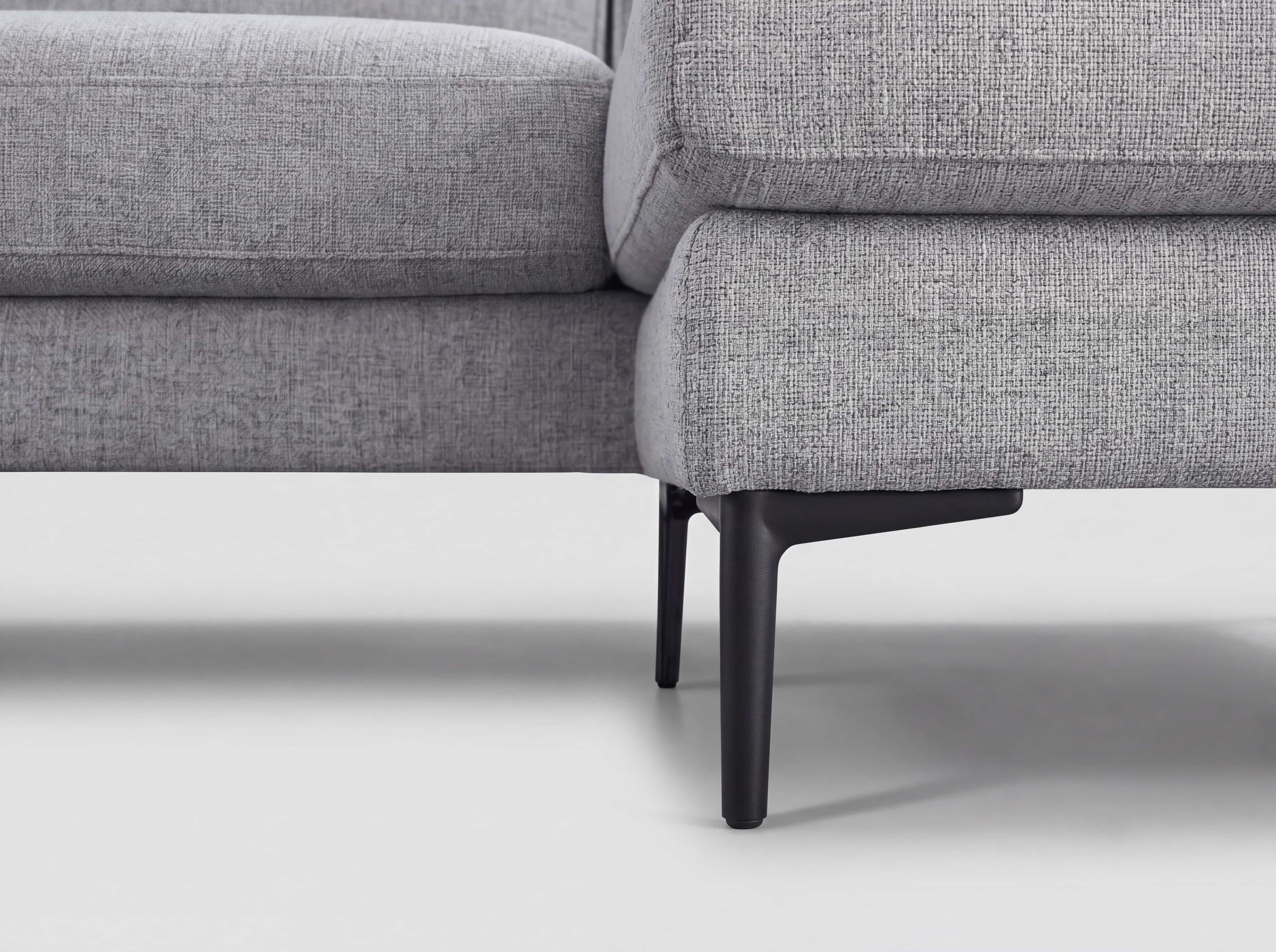 Ecksofa mit grauem Stoffbezug und schwarzen Metallfüßen, Polsterung mit sichtbarer Struktur