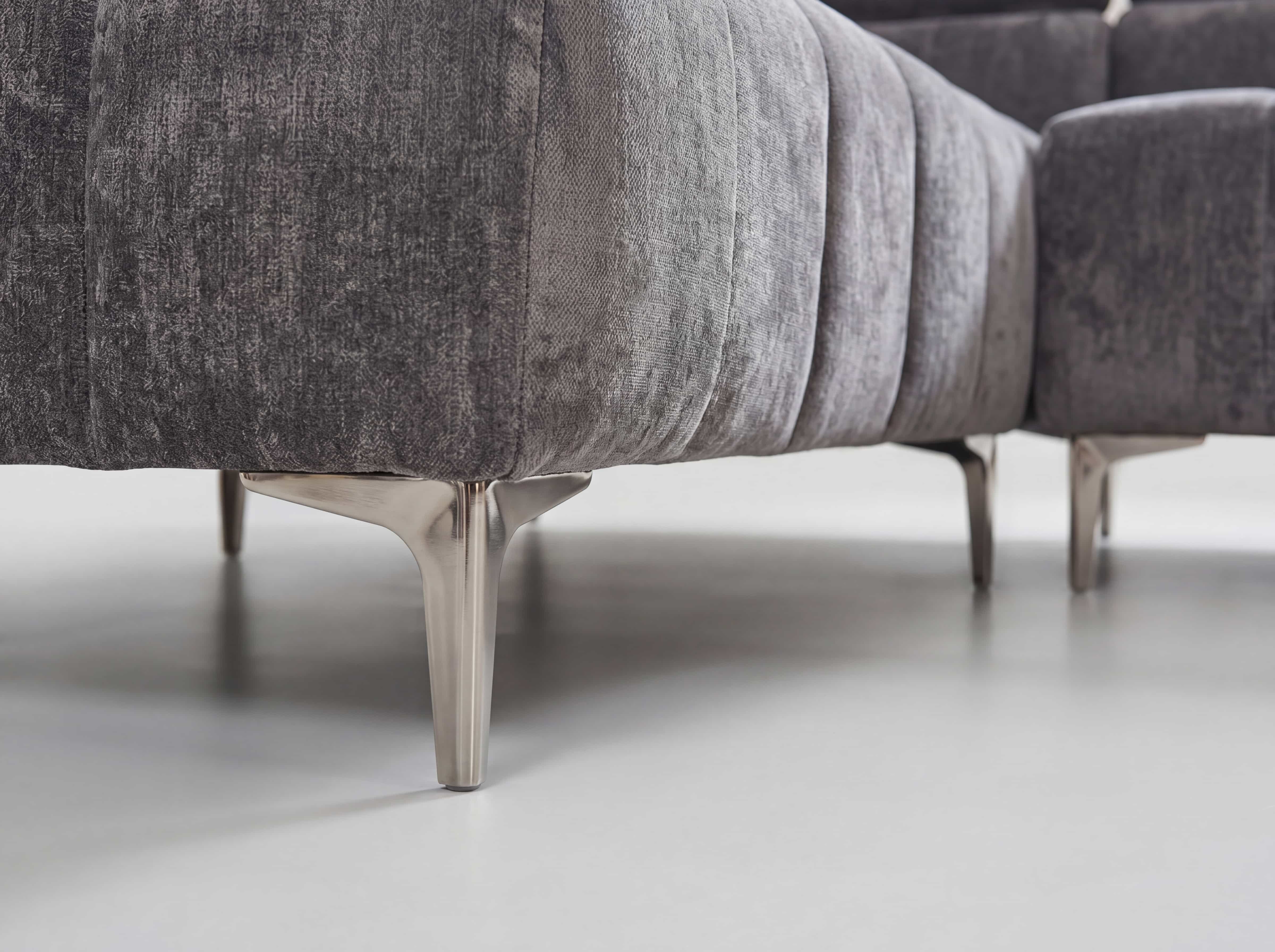 Ecksofa mit grauem Stoffbezug, senkrechter Steppung und metallfarbenen, schmalen Füßen