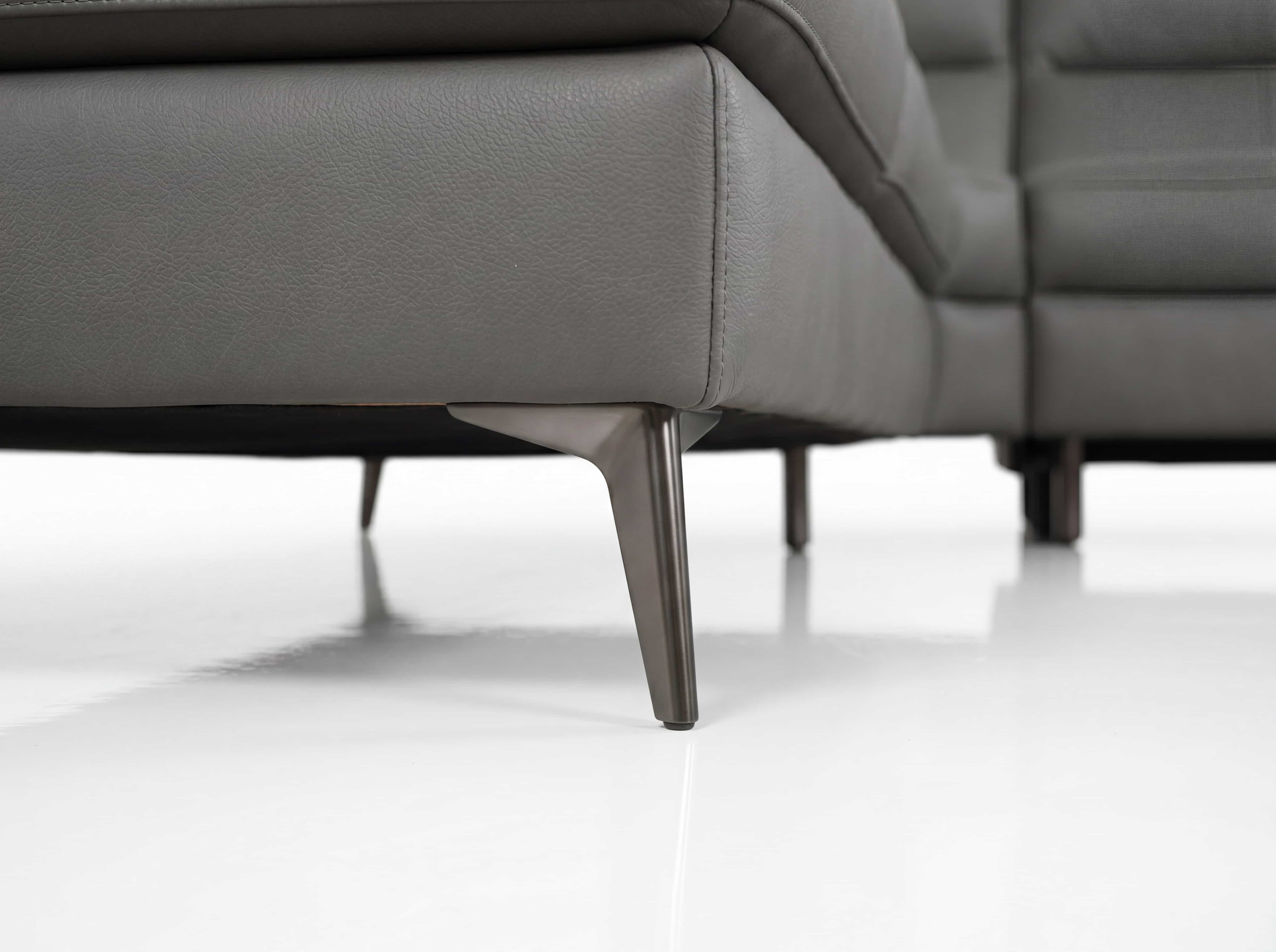 Ecksofa Kabs mit grauem Lederbezug und schlanken, spitz zulaufenden Metallfüßen in Nahaufnahme