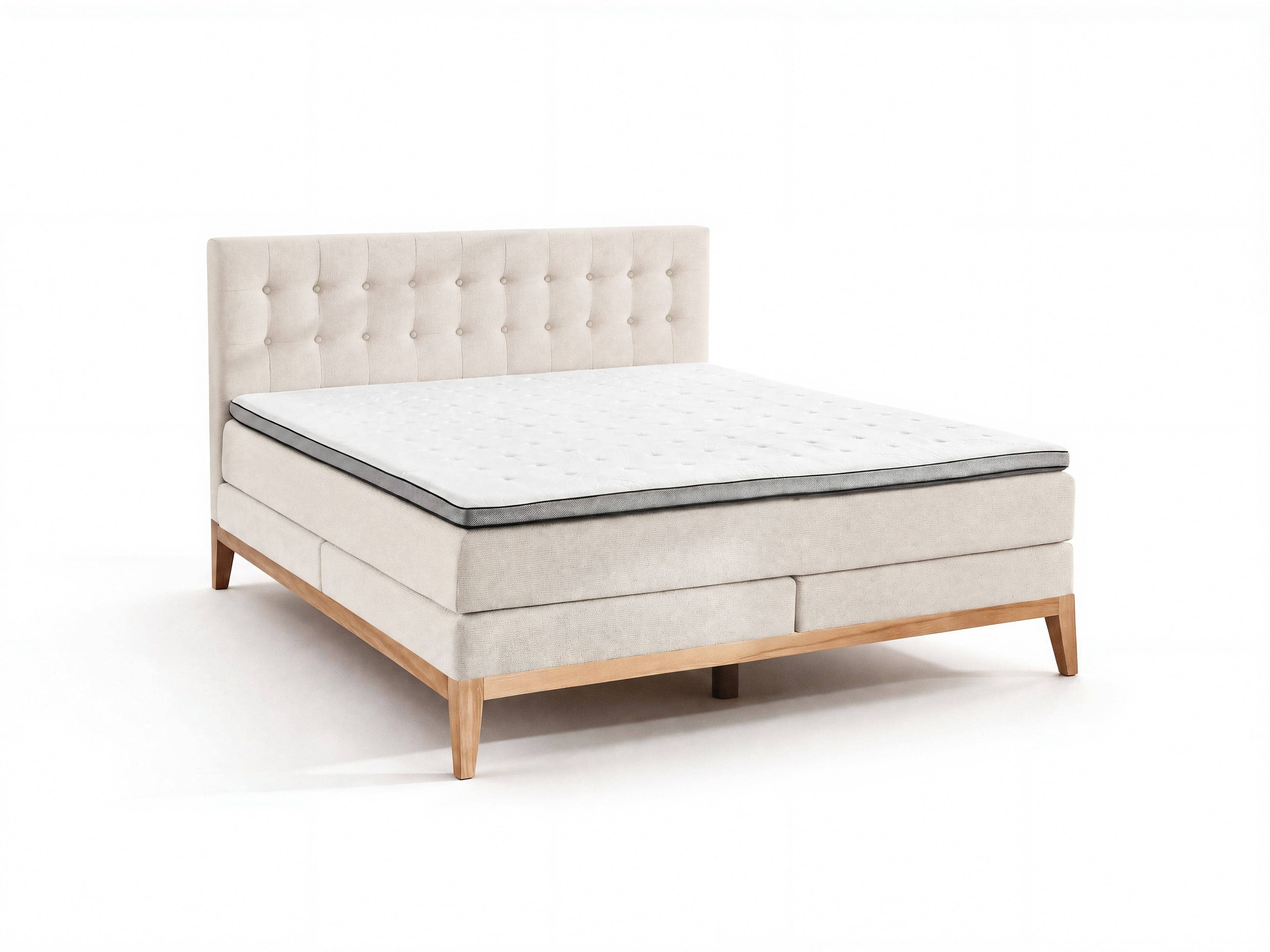 Boxspringbett mit gepolstertem, beige Stoff bezogenem Kopfteil, Knopfheftung und Holzfüßen
