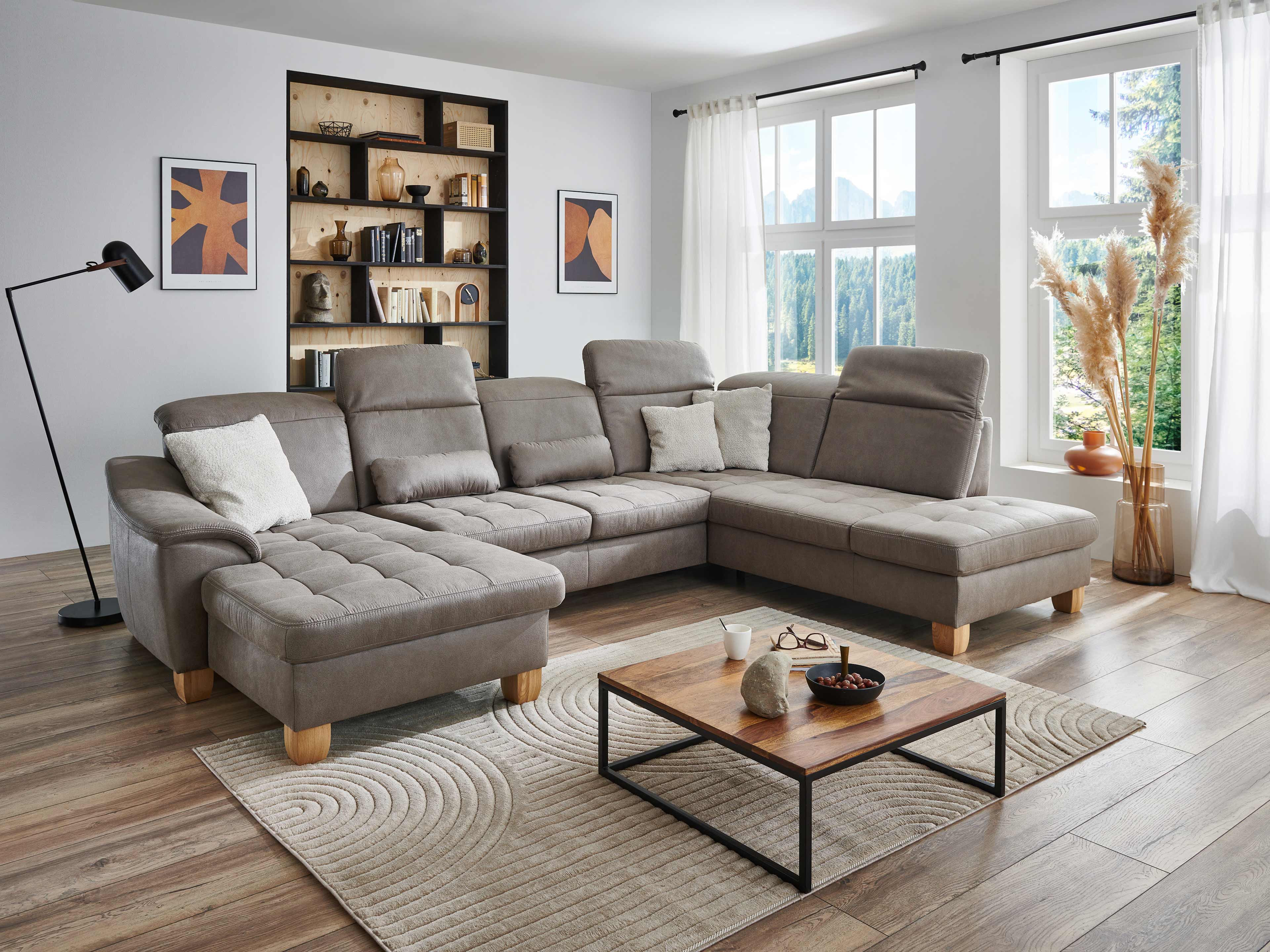 Ecksofa Edda mit grauem Stoffbezug, gepolsterten Sitzflächen, Armlehne und Holzfüßen