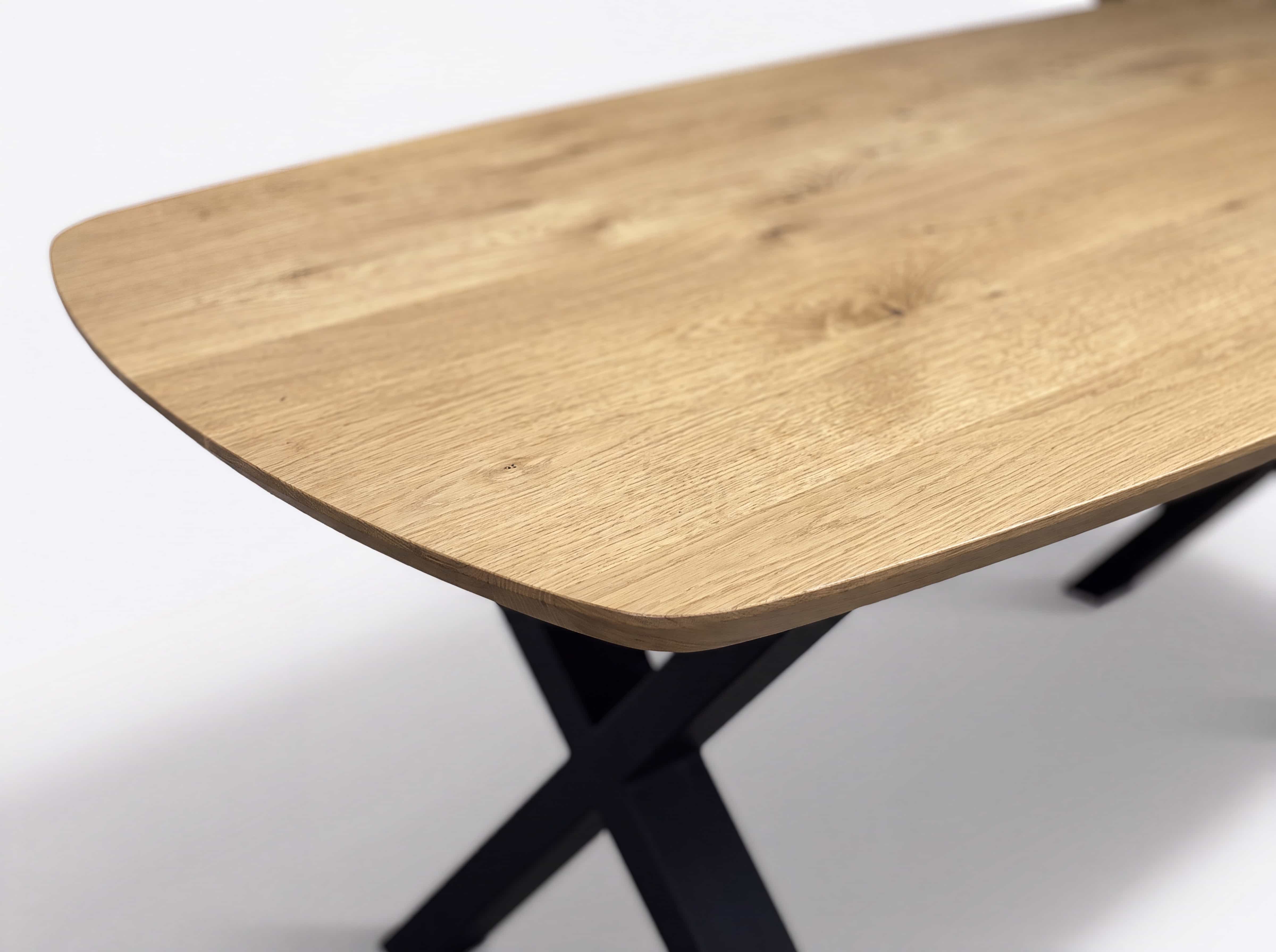 Esstisch mit rechteckiger Tischplatte aus hellem Holz und schwarzem, gekreuztem Metallgestell